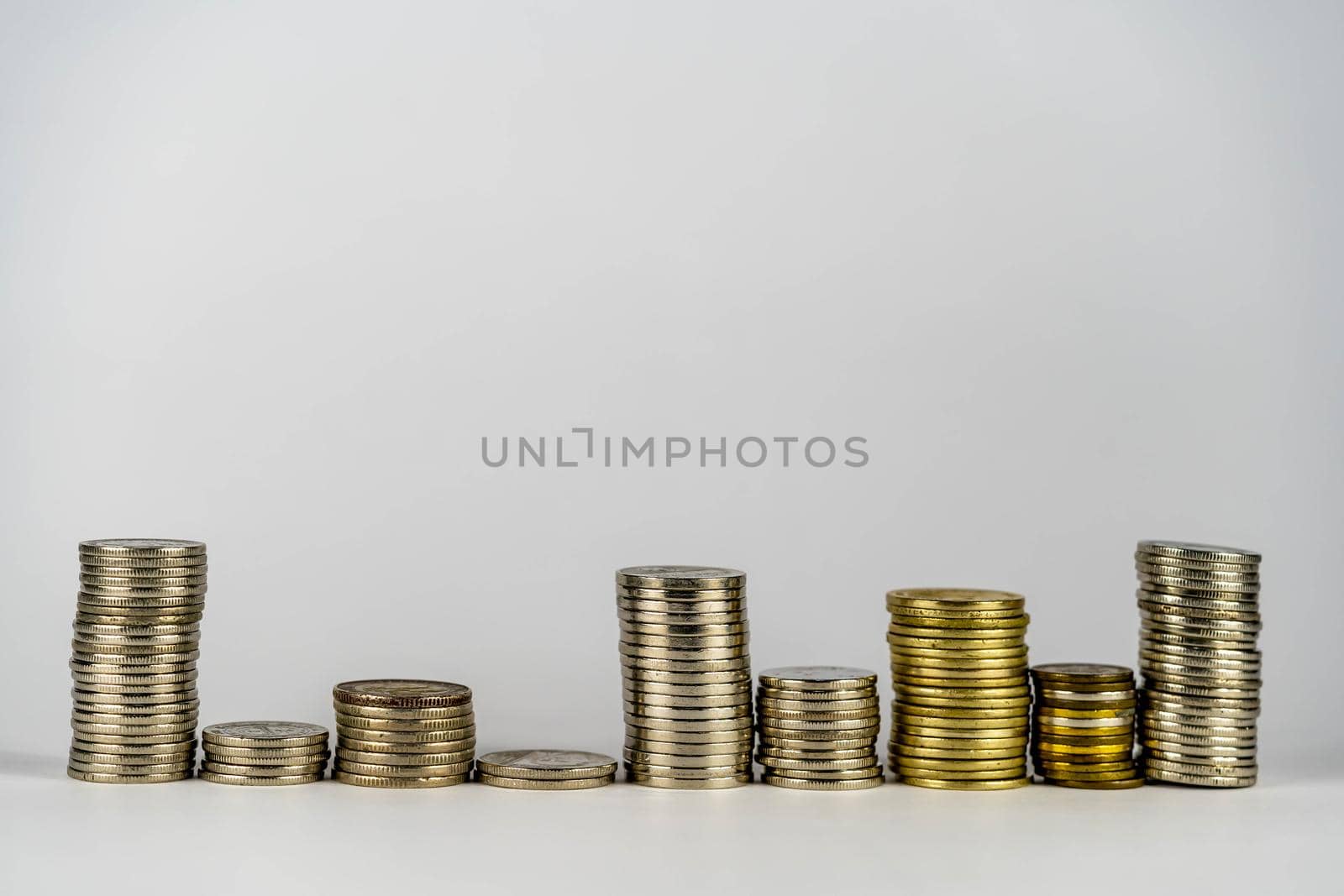 stacking of coins on top of the coin pile on the highest row. Placing coins in a row from low to high is comparable to saving money to grow more. Money saving ideas for investing in funds. by billroque