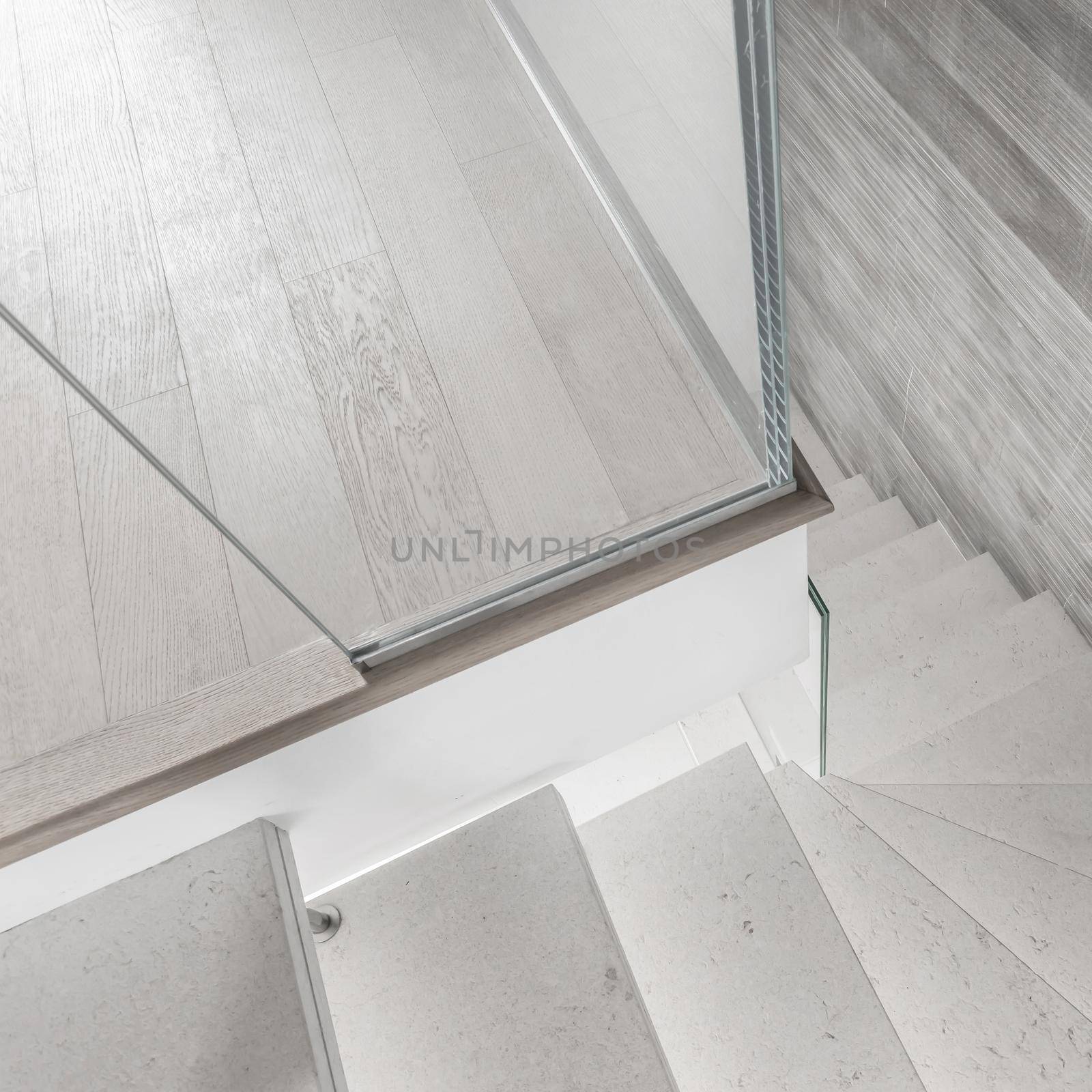 Modern design and innovative material. Microcement stairs with glass handrail. Stairs viewed from above. Glass railing.