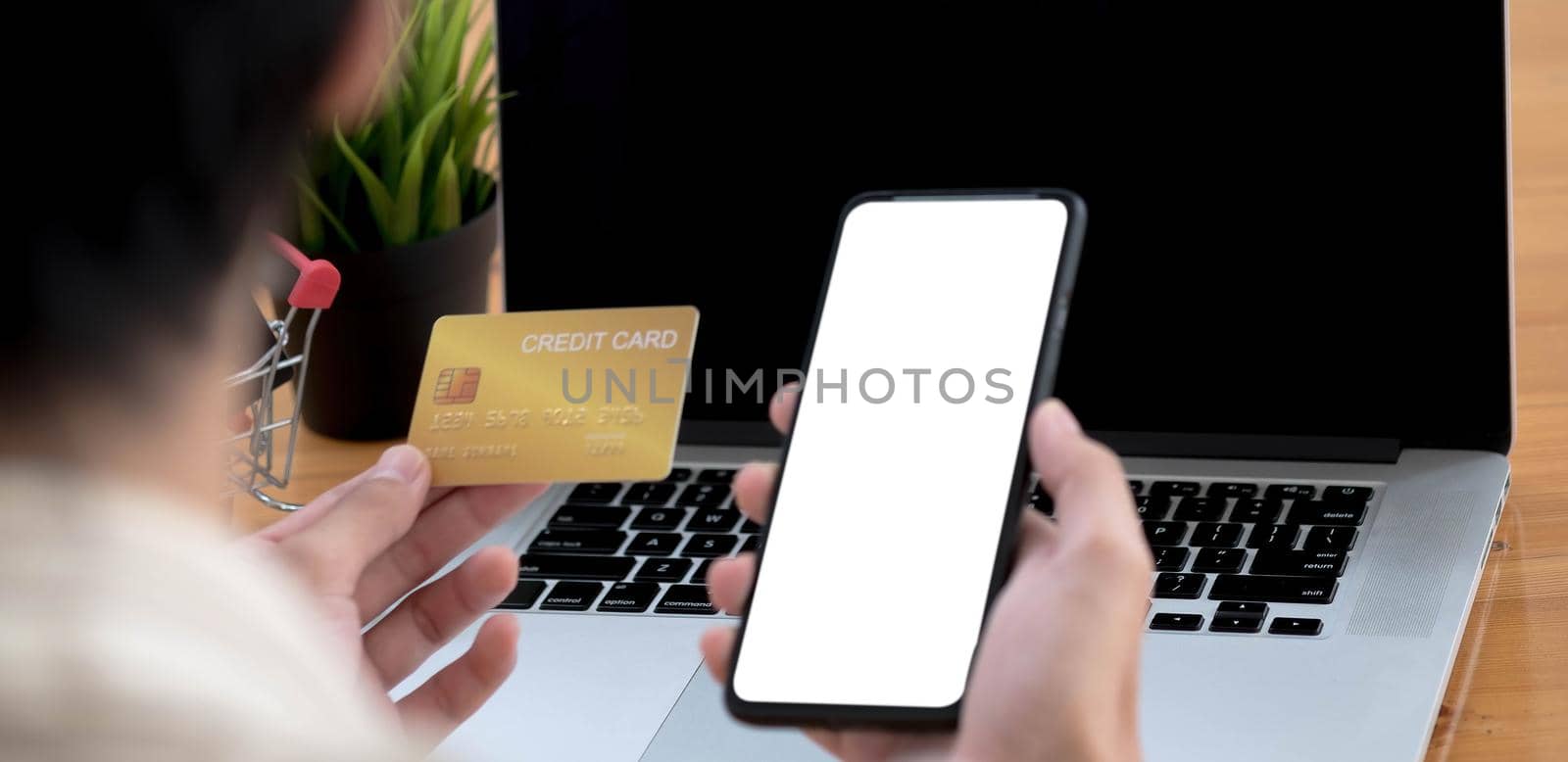 Man holding credit card and using smartphone at office panoramic banner, businessman shopping online, e-commerce, internet banking, spending money, working from home concept.