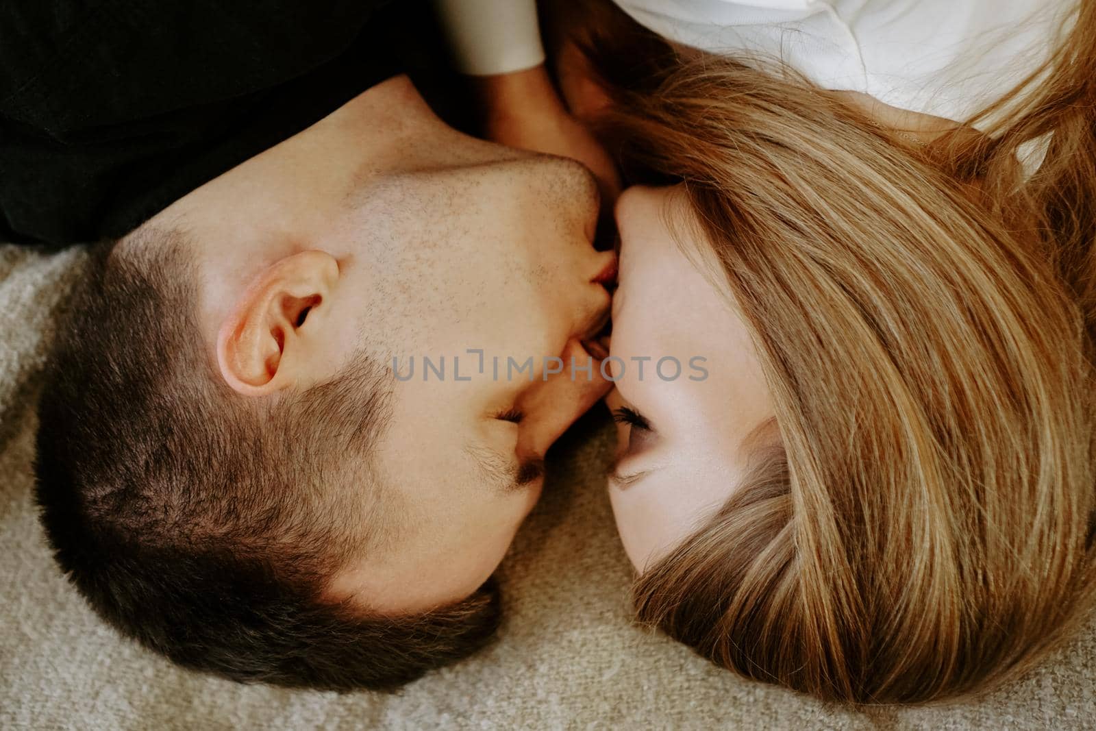 Close-up portrait of a young couple in bed at home - top view