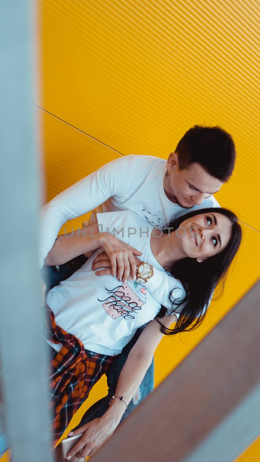 Image of Young lovely couple posing together and hugging over yellow background