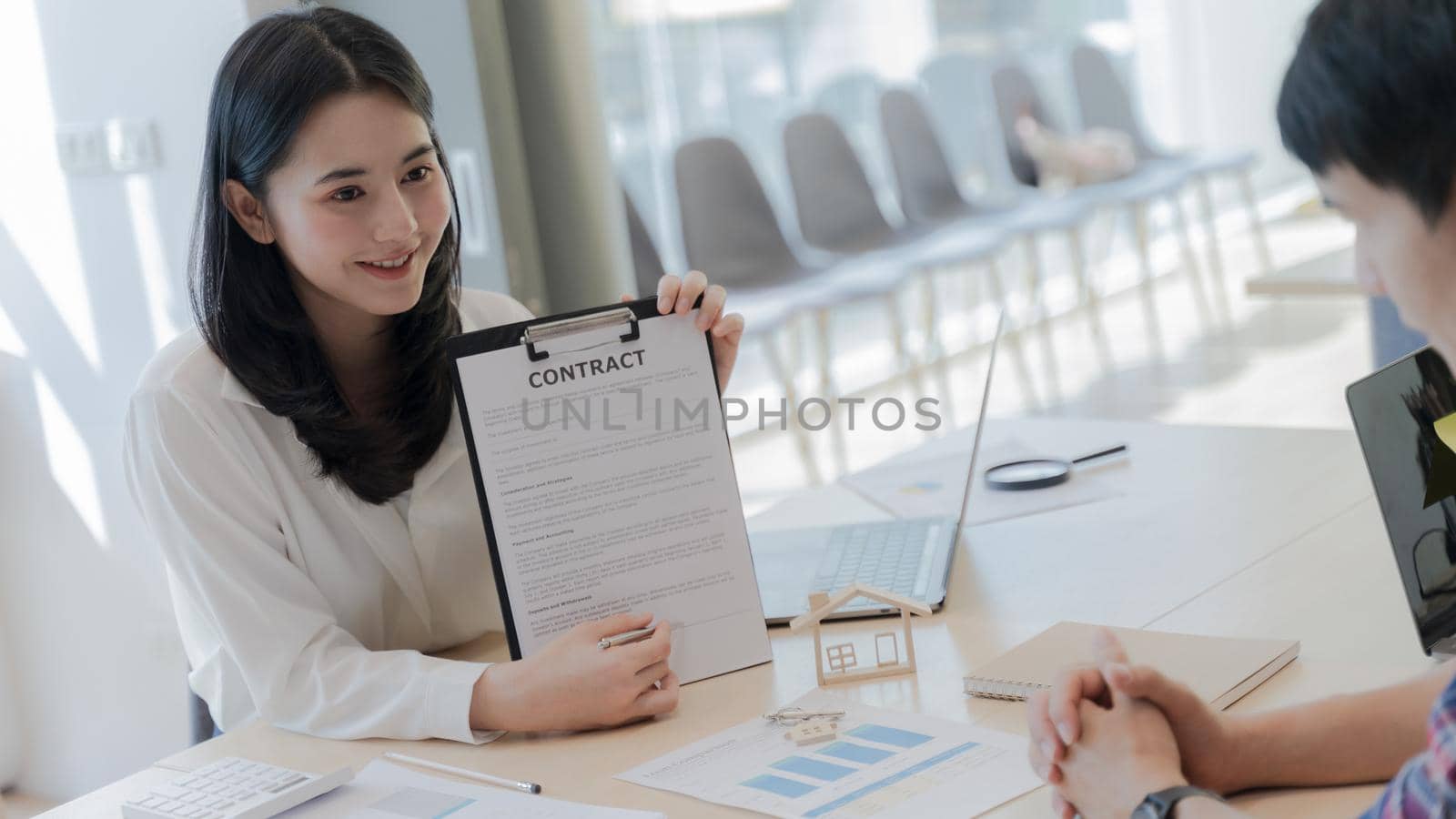 Women professional real estate agent show signing point on the contract agreement about house purchase contract, loan agreement, mortgage contract to Customers interested in buying a house. Portrait.