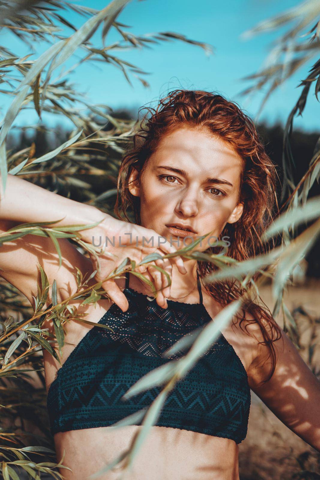 Woman in bikini on a tropical beach with plants - summer time