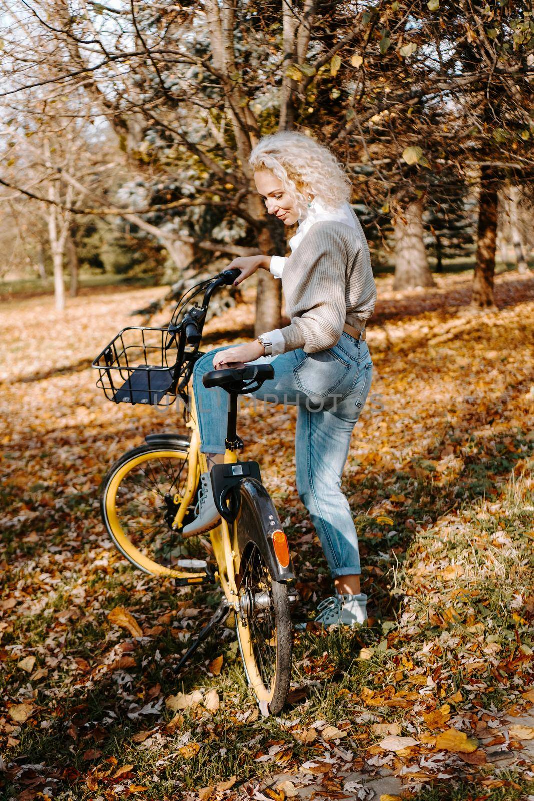Woman on a Bicycle walking in the autumn Park by natali_brill