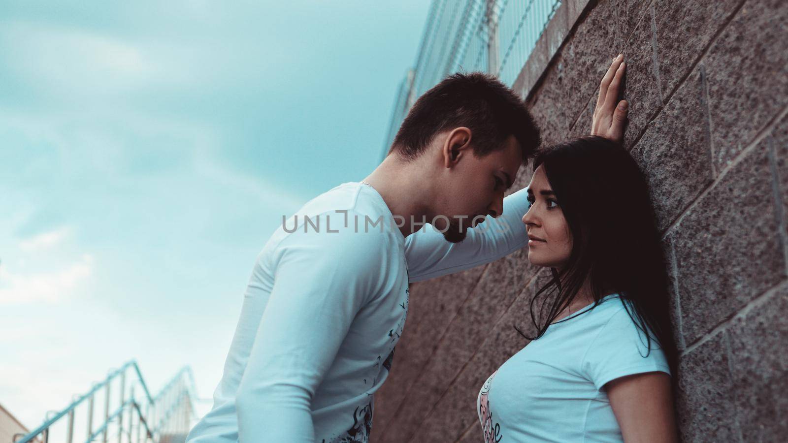 Young loving couples standing next to the brick wall, happy and satisfied, lifestyle concept