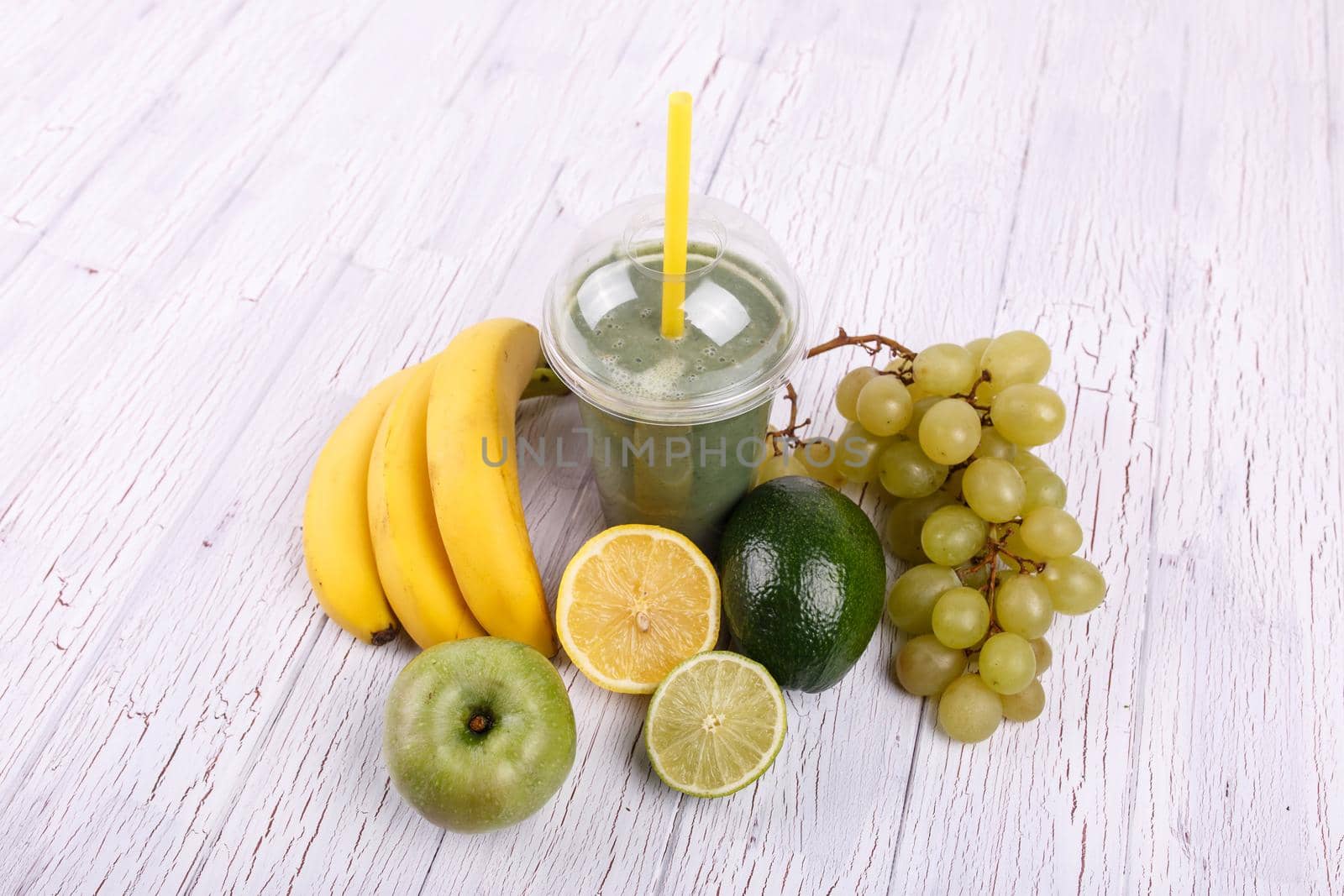 healthy smoothie with bananas,lime and grape lie on the table