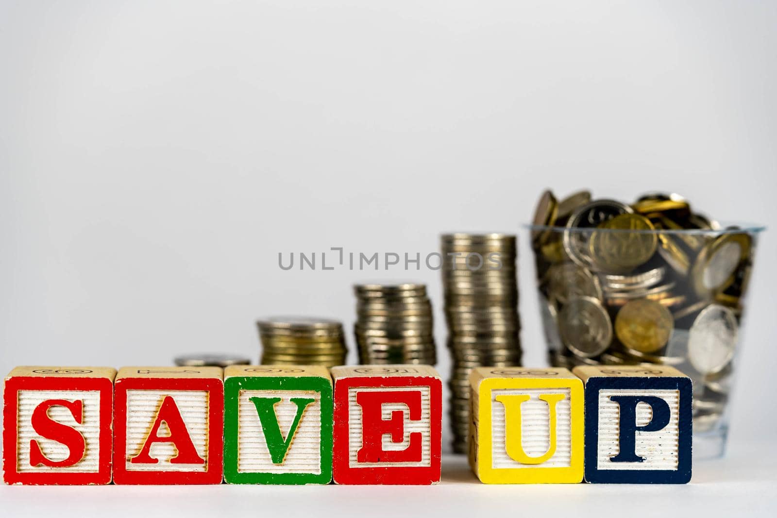 Money coins stack stair as step growing growth and wooden cube block with word SAVEUP. Investment and save money concept. save up money. save up on savings