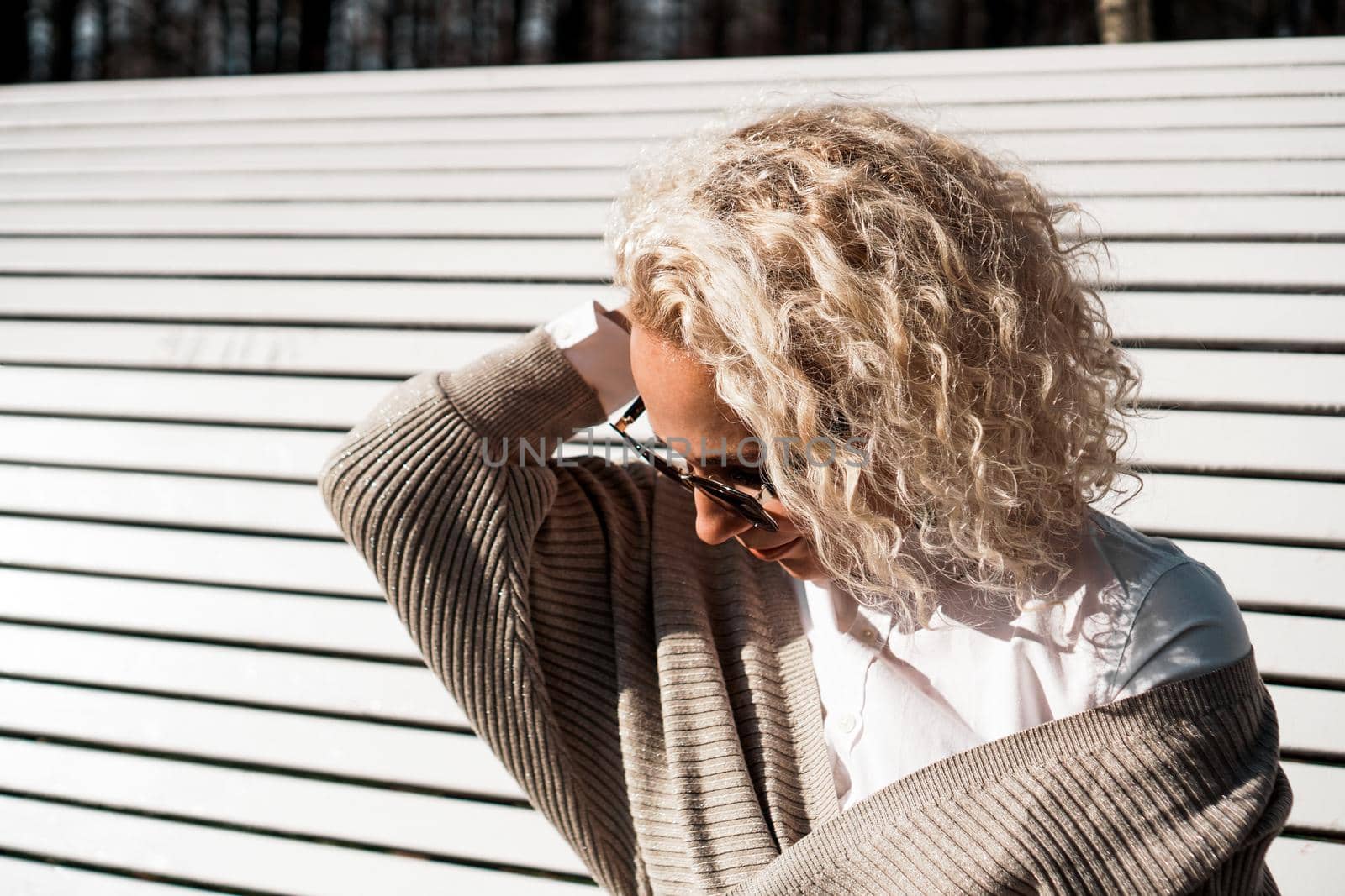 Pretty woman in sunglasses on bench at autumn park alone, lifestyle people concept