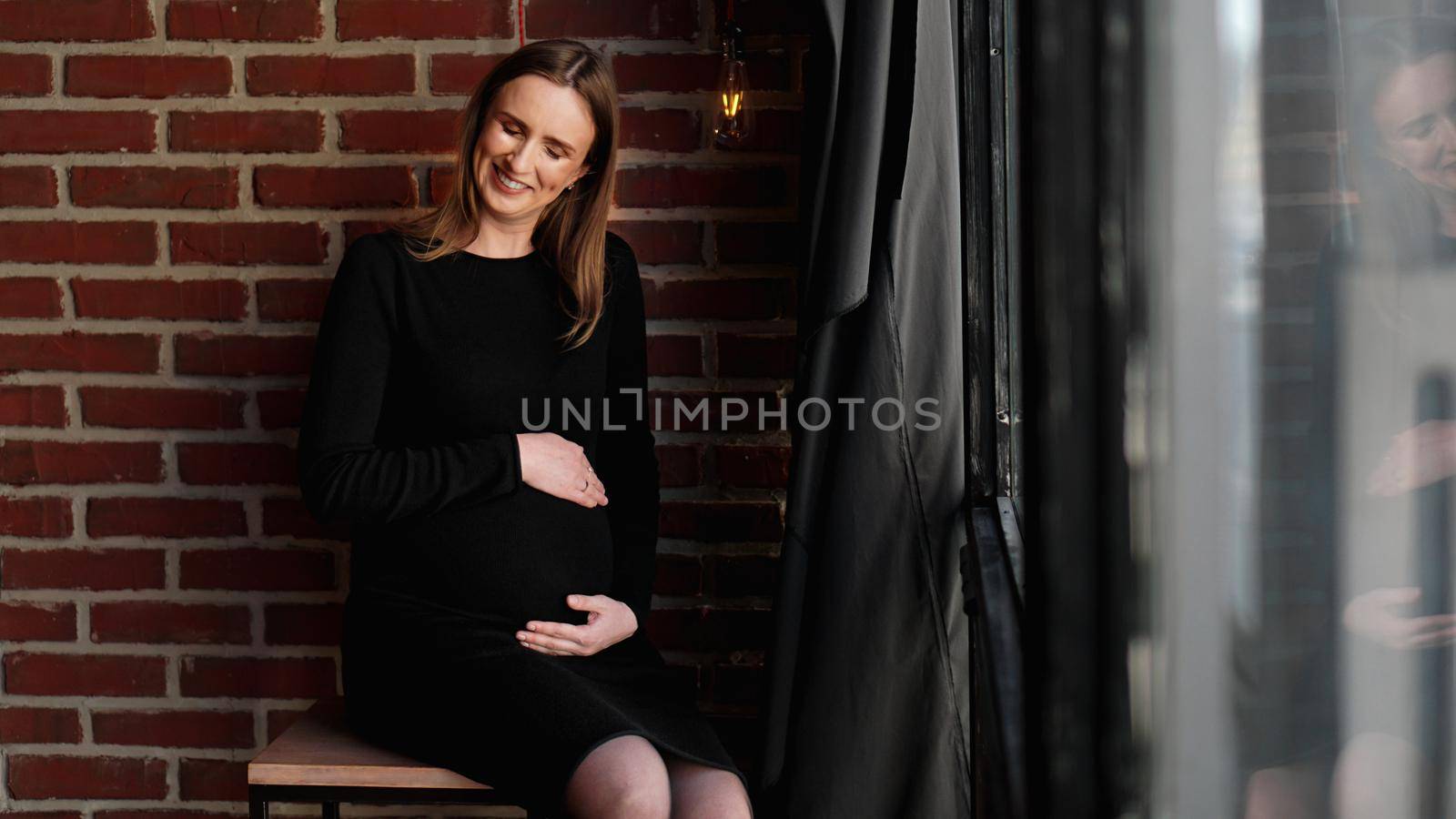 Young pretty pregnant woman in black dress in studio by natali_brill