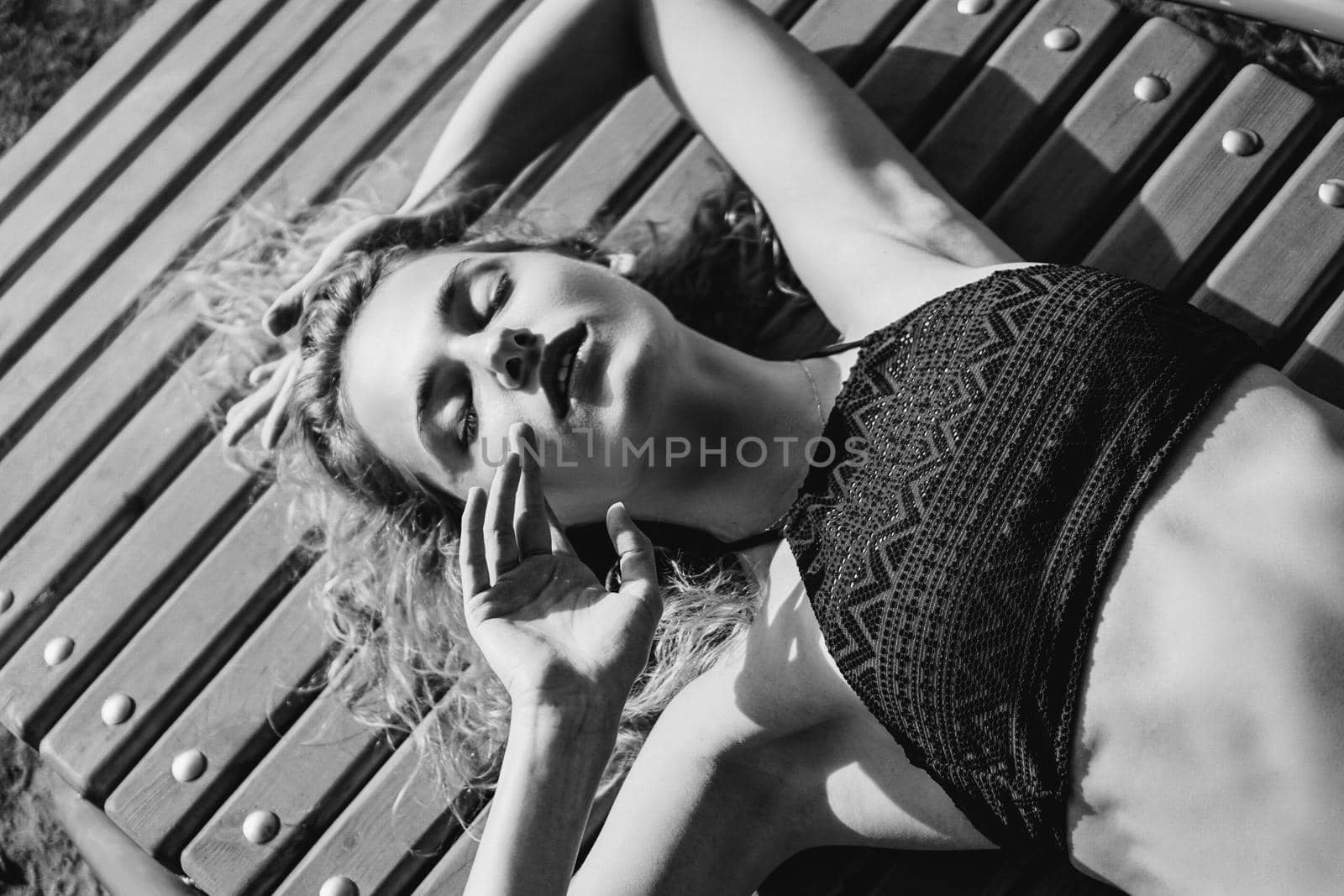 Portrait of beautiful young woman in the swimsuit relaxing on the beach - Black and white fashion portrait