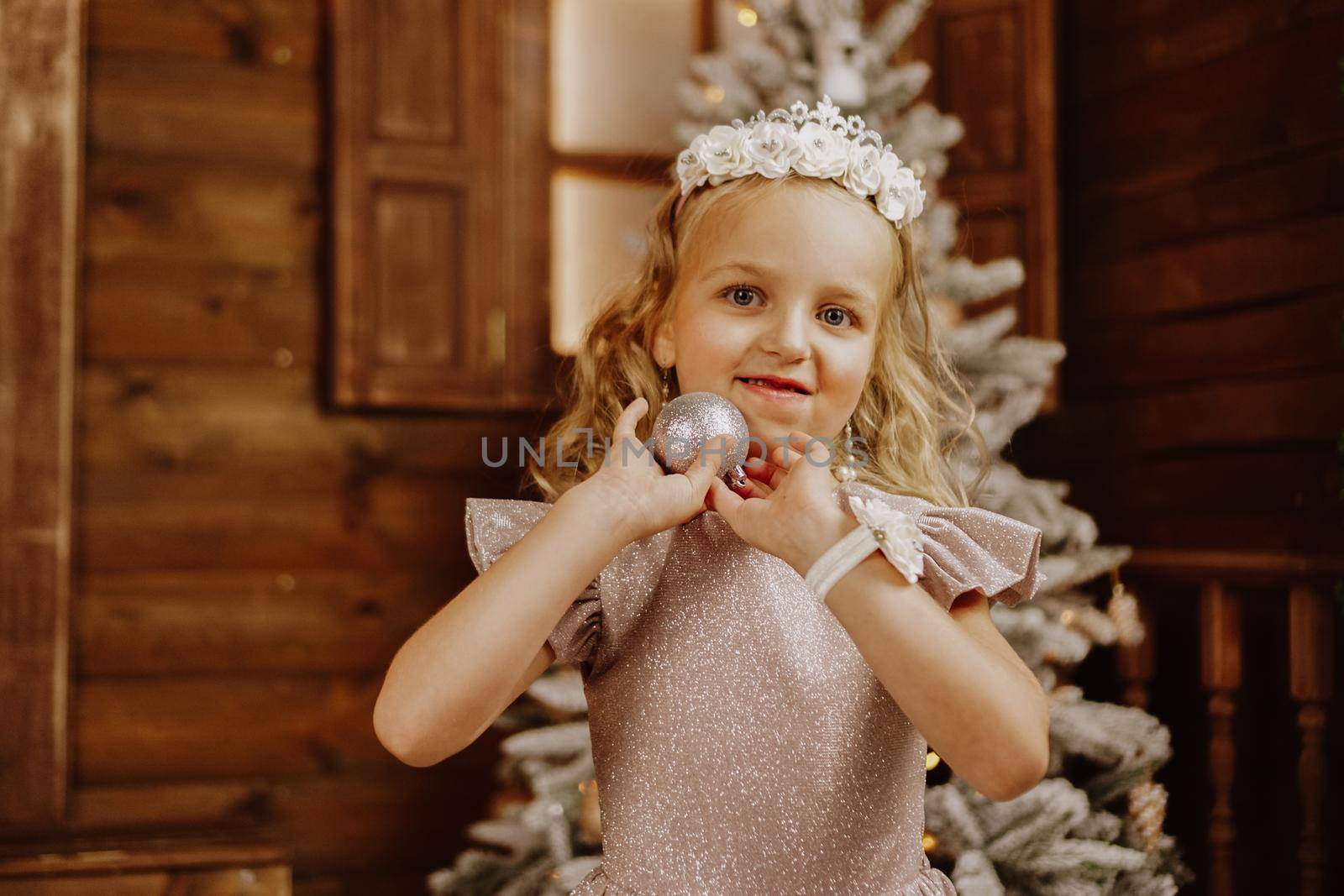 Little girl with blond hair in pink dress in new year background by natali_brill