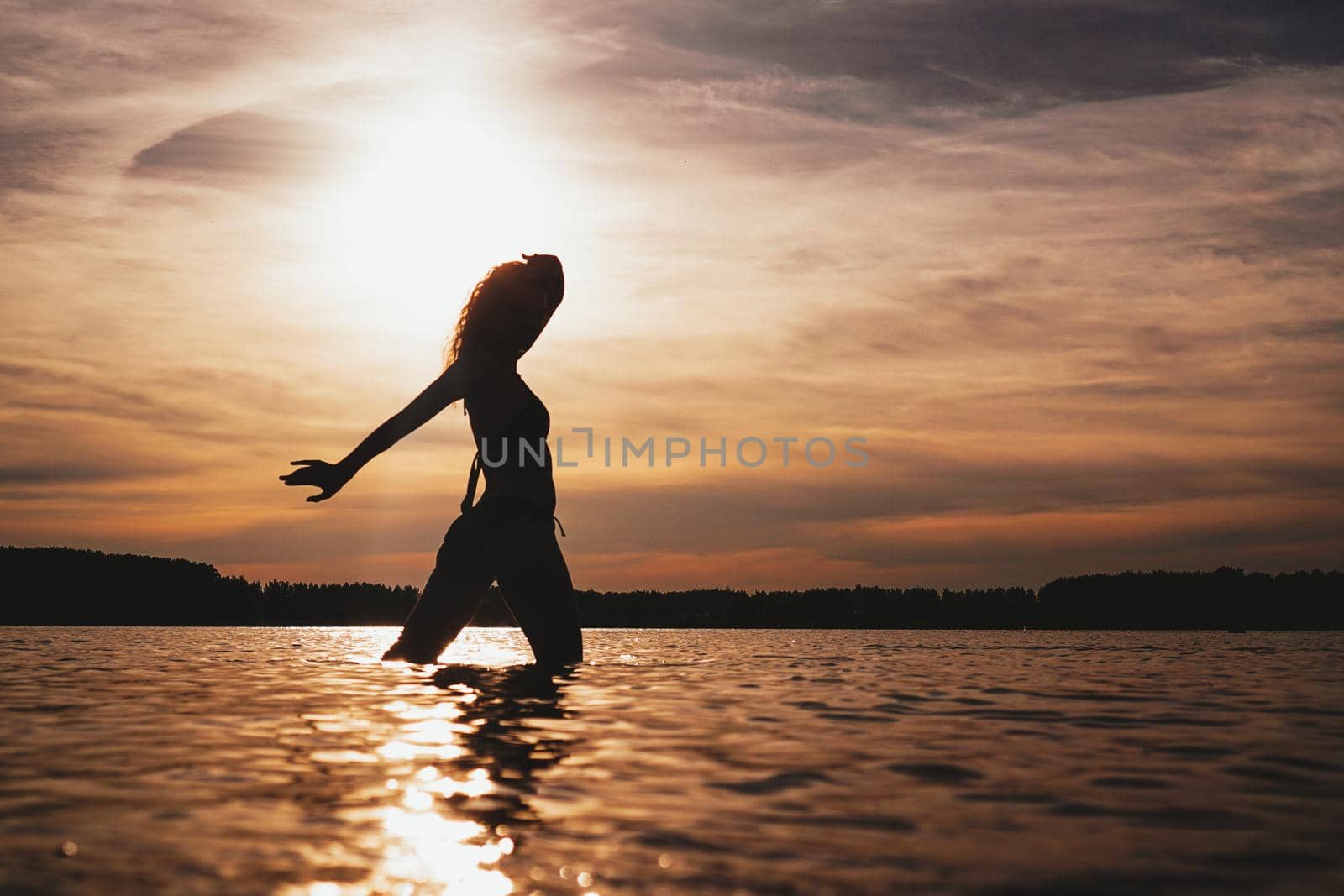 Happy Carefree Woman Enjoying Beautiful Sunset on the Beach - Summer photo