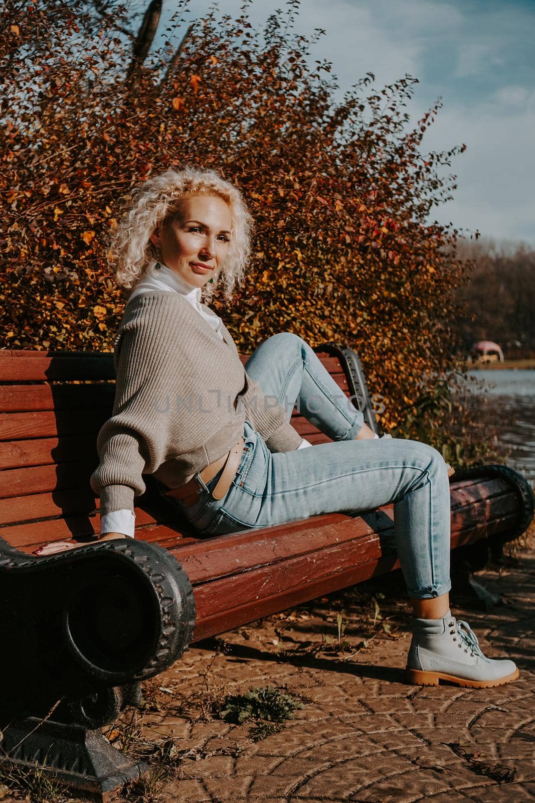 Middle-aged Woman sitting on the bench at autumn city park