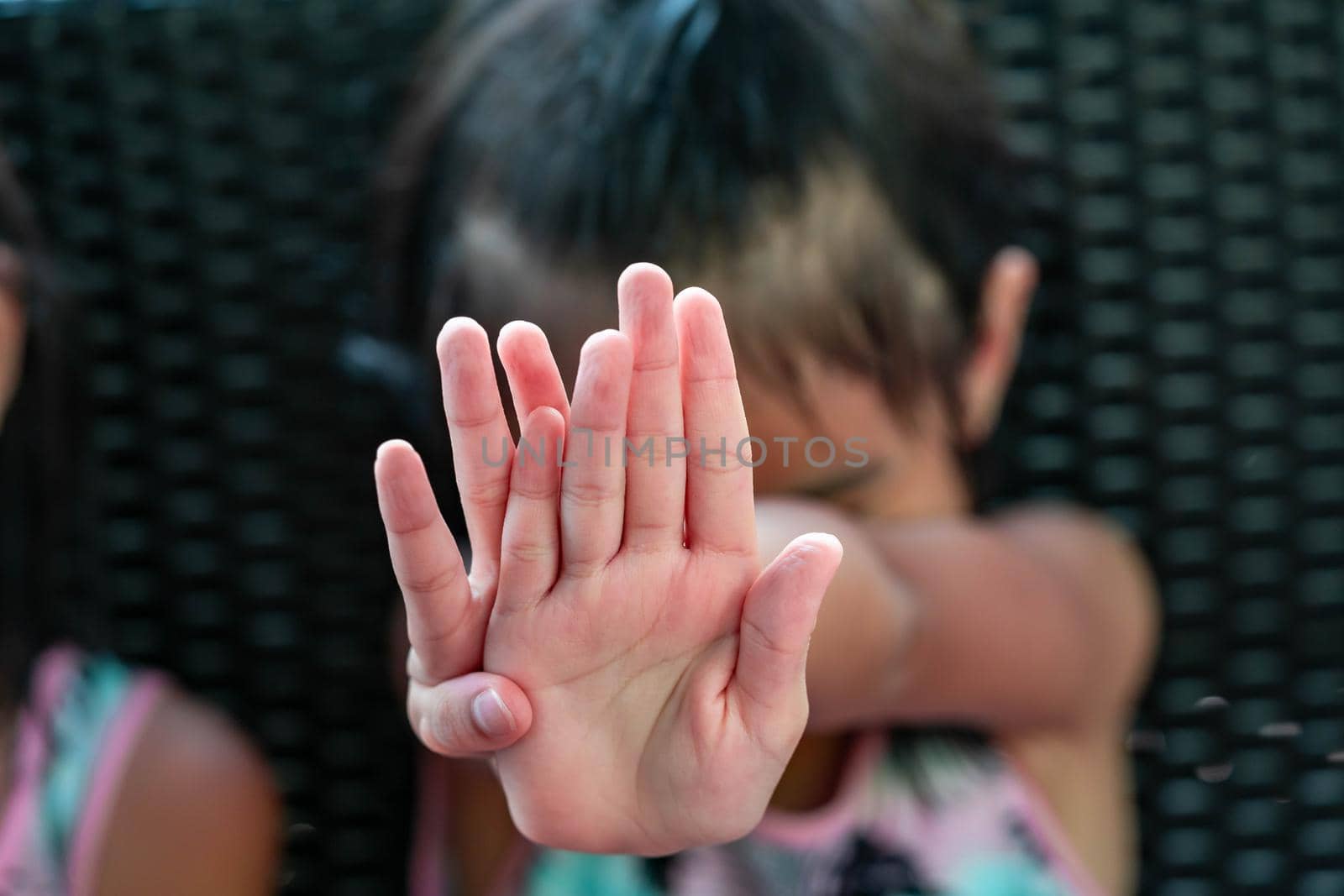 Female child showing palm of hand saying no. Child saying no to camera by billroque