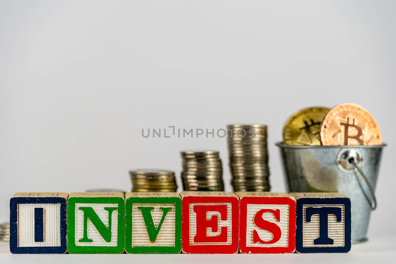 Money coins stack stair as step growing growth and wooden cube block with word INVEST. Investment and save money concept. Invest on bitcoin. Invest on crypto by billroque
