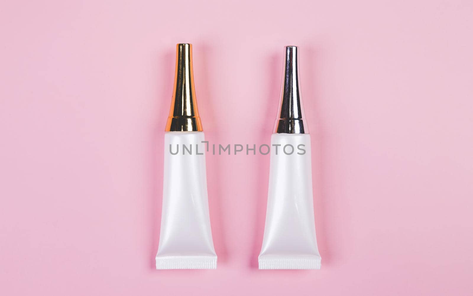 Mockup cosmetic tube with cream or lotion isolated on pink background, mock up package for advertising, skincare or cosmetology, top view, flat lay, skin care and treatment with product.