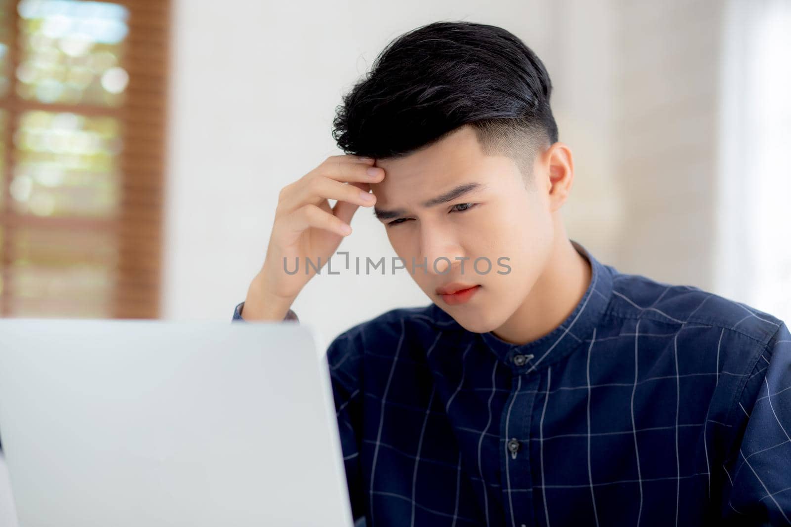 Young asian business man headache during working on laptop computer with deadline on desk at home, businessman with failure exhausted and tired, stress and worried, frustrated and unsuccessful.