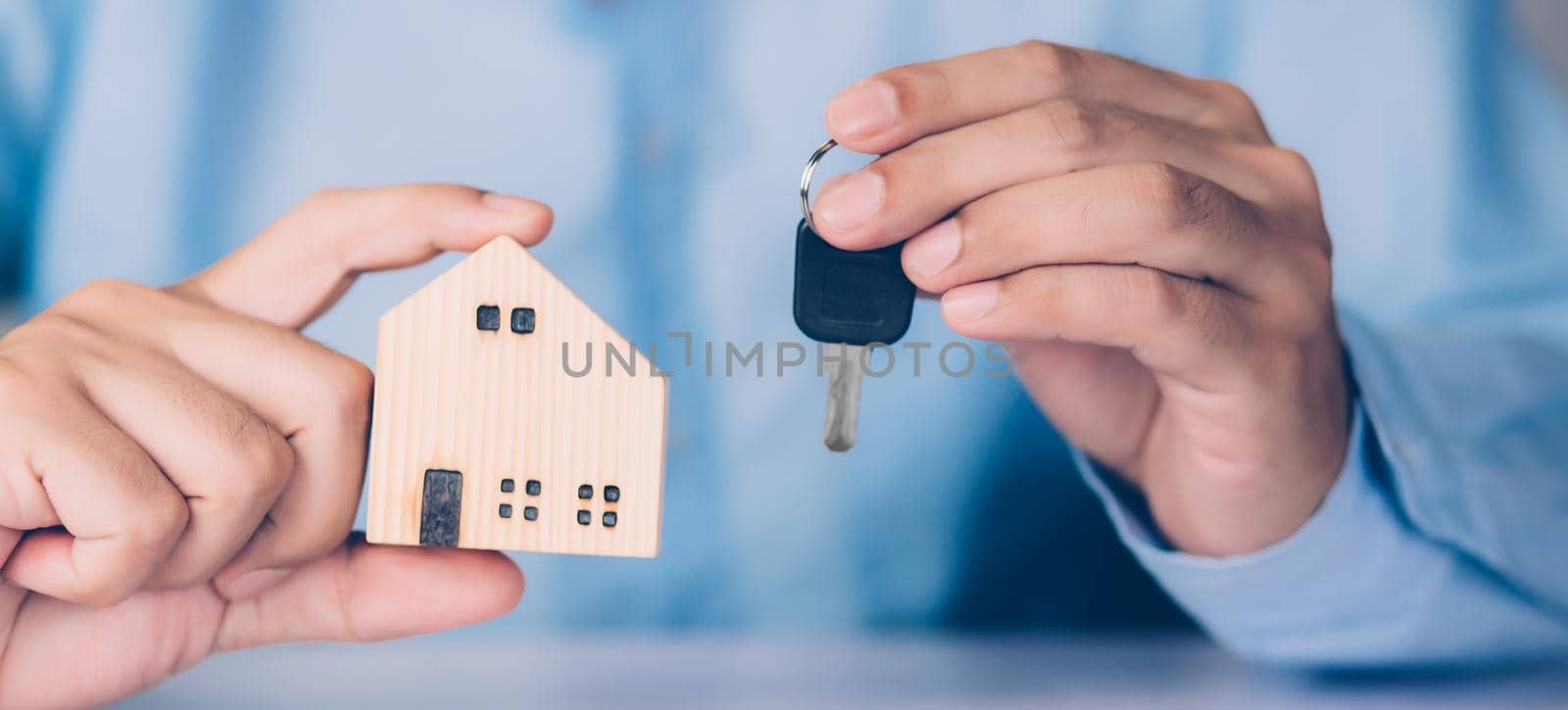 Hand of businessman is agent holding key house, insurance home and real estate for investment, residential and agreement with approval, loan, debt and financial, business and property concept. by nnudoo