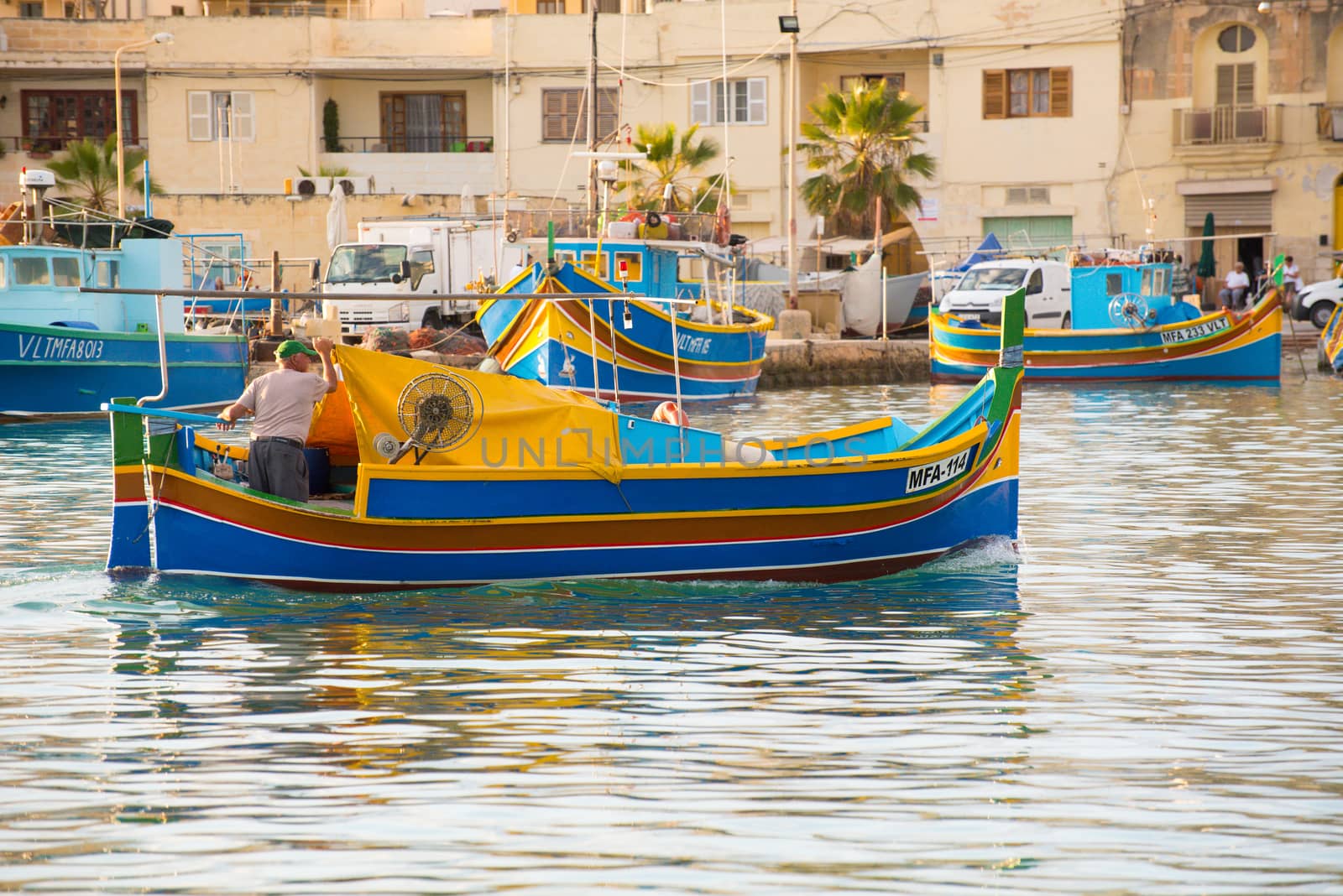 Traditional eyed colorful boats Luzzu in the Harbor of Mediterranean fishing village Marsaxlokk, Malta