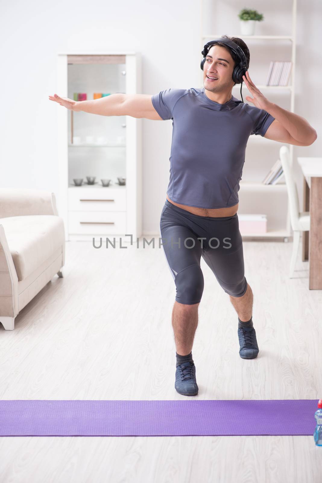 Man doing sports at home and listening to music