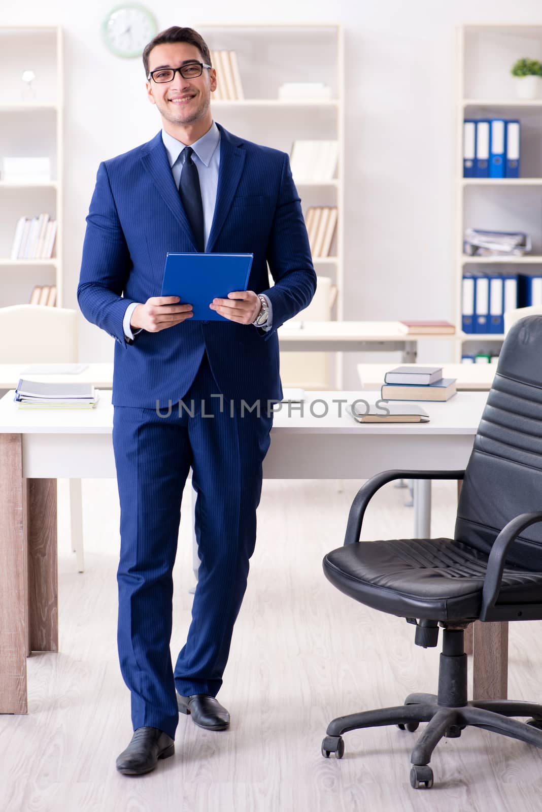 Young handsome businessman employee working in office at desk