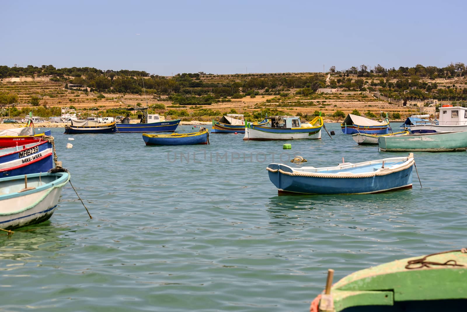 Traditional eyed colorful boats Luzzu in the Harbor of Mediterranean fishing village Marsaxlokk, Malta