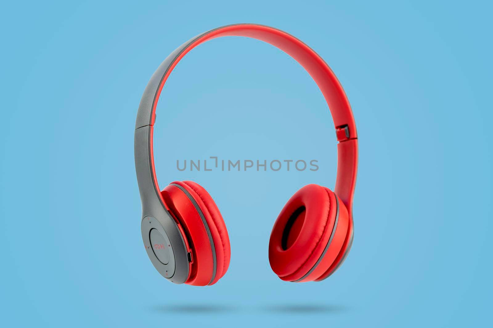 Modern design of red color wireless earphones isolated on blue pastel color background. by wattanaphob