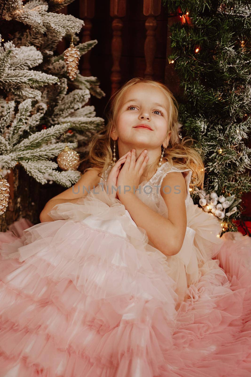 Girl in a pink dress near the Christmas tree by natali_brill