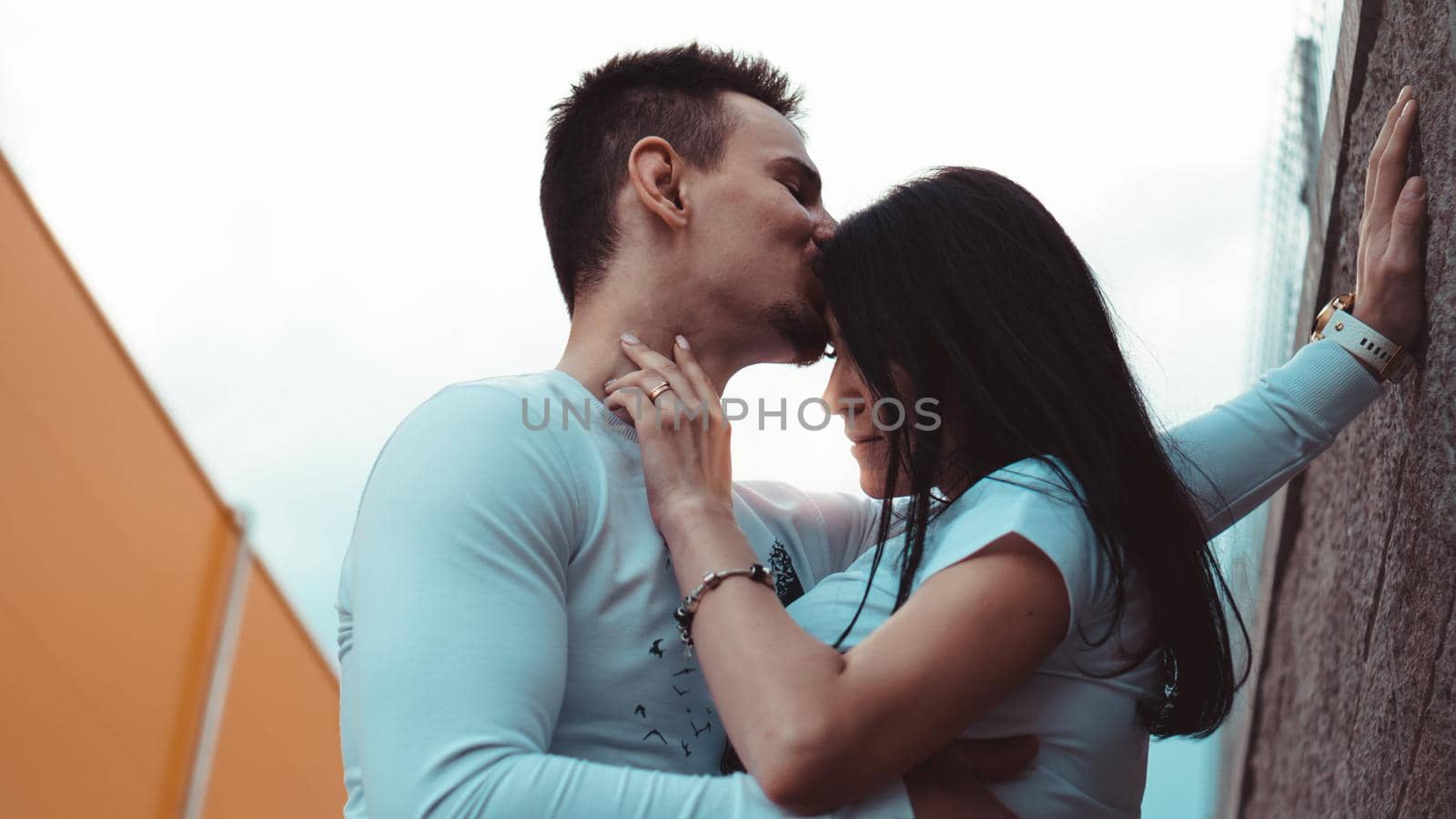 Young loving couples standing next to the brick wall, happy and satisfied by natali_brill