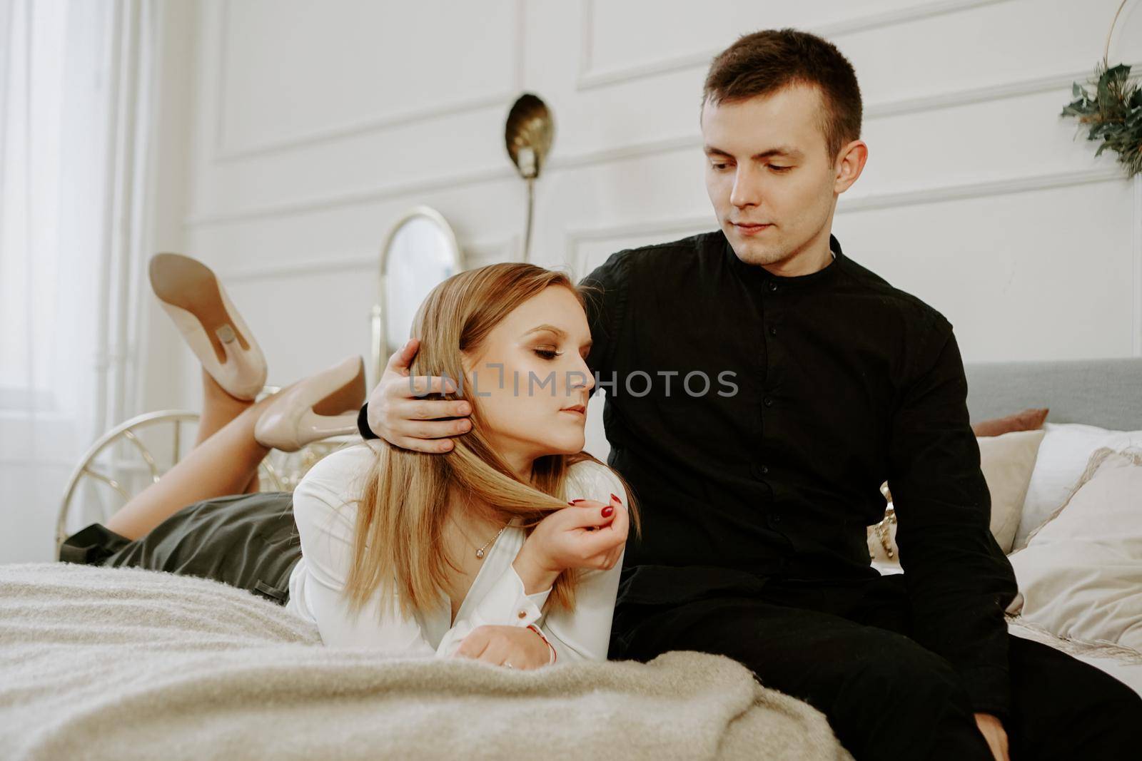 Business couple on bed in hotel room by natali_brill