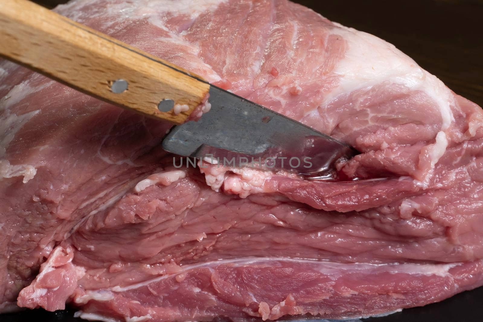 Slice the pork or beef with a knife on the table in close-up.Preparation of meat dishes and food products.Pieces of red meat for shish kebab,barbecue or kebab.Raw fresh meat is cut with a knife.recipe