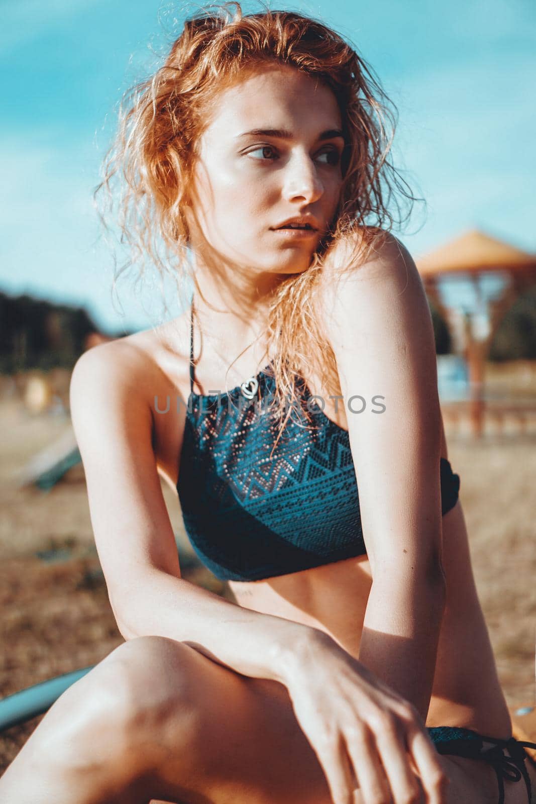 Portrait of beautiful young woman in the swimsuit relaxing on the beach - fashion portrait