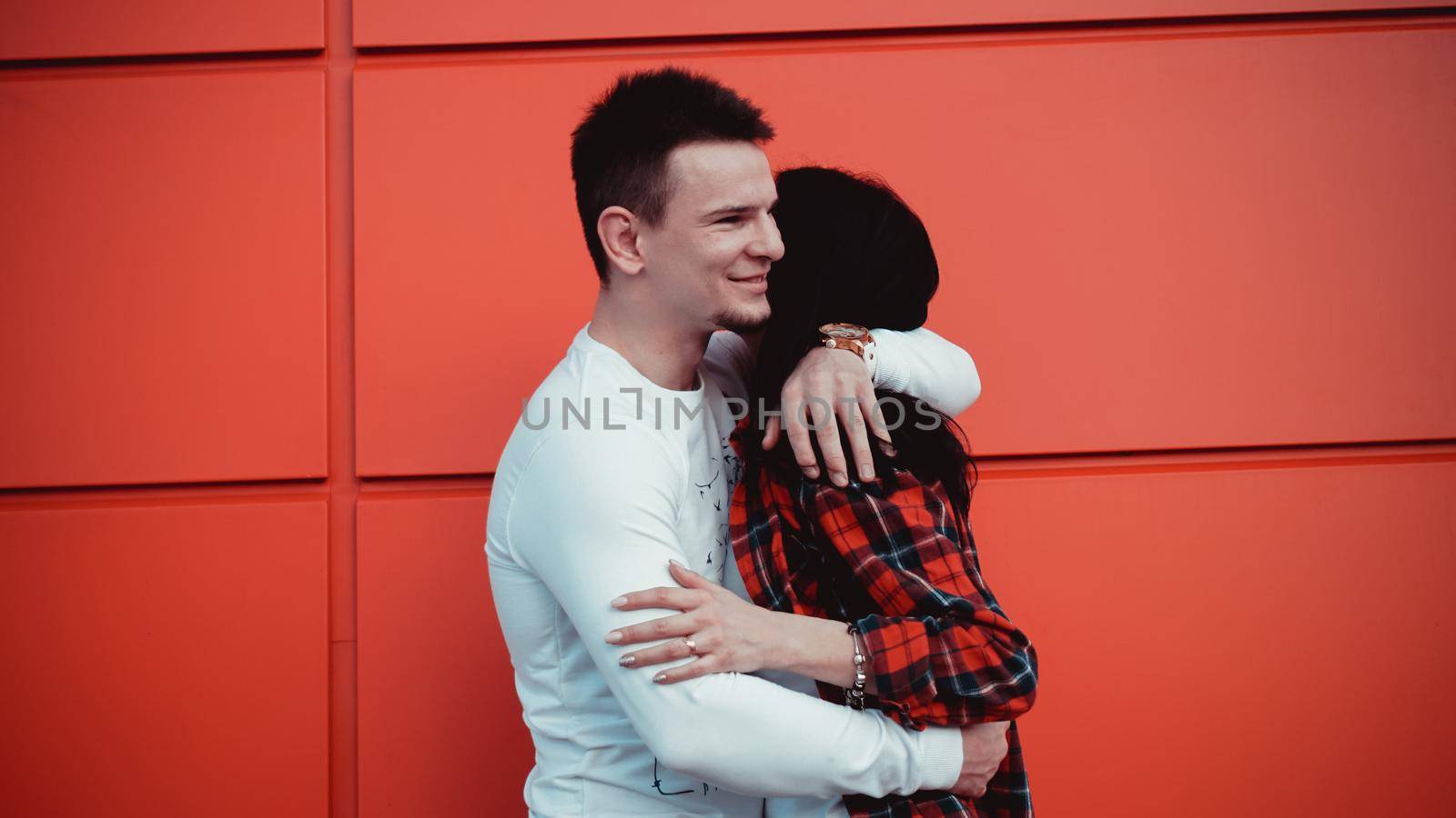 Couple dating and hugging in love in a sunny day - red background by natali_brill