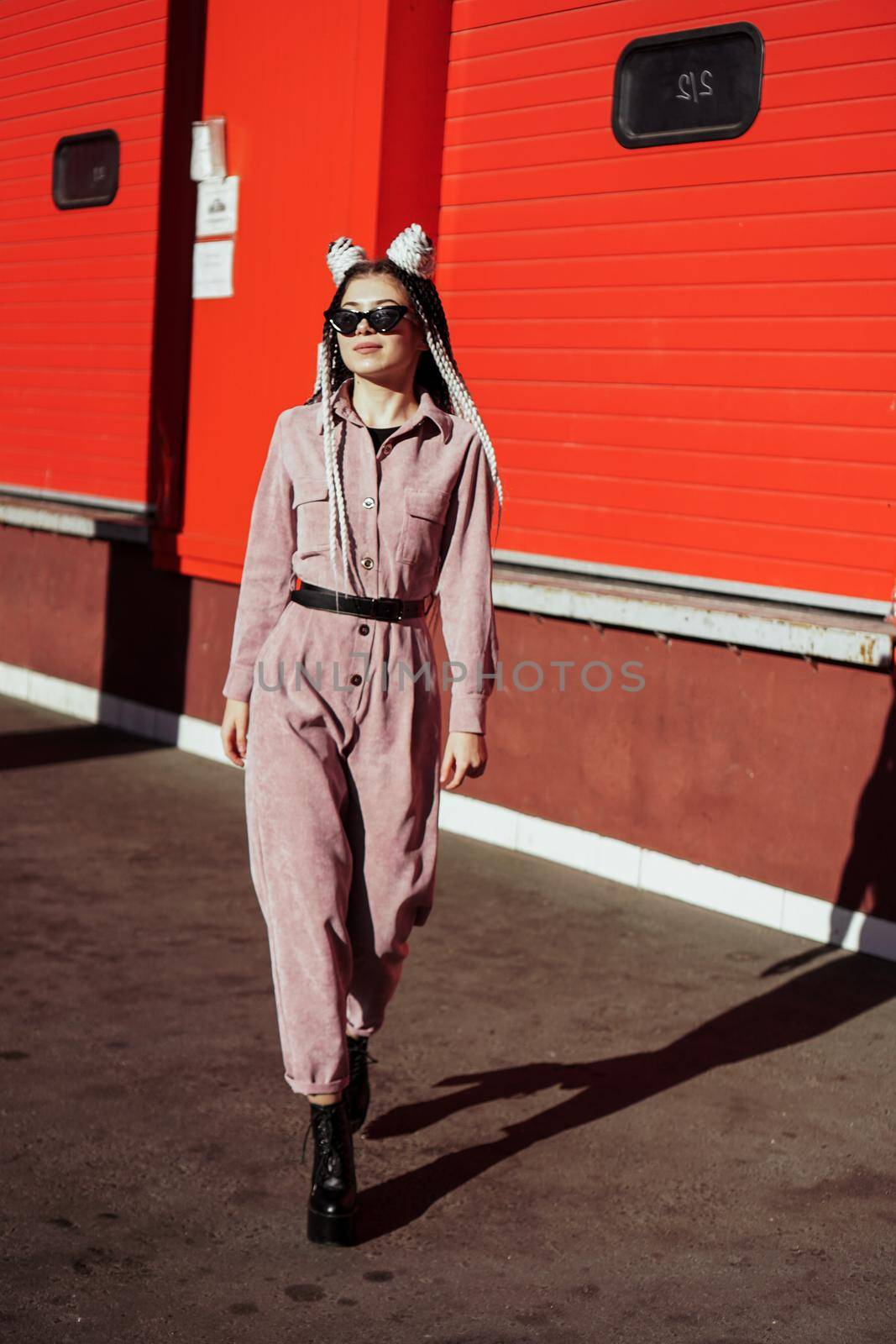 Beautiful cool girl with dreadlocks full length. Photo in the city - urban style