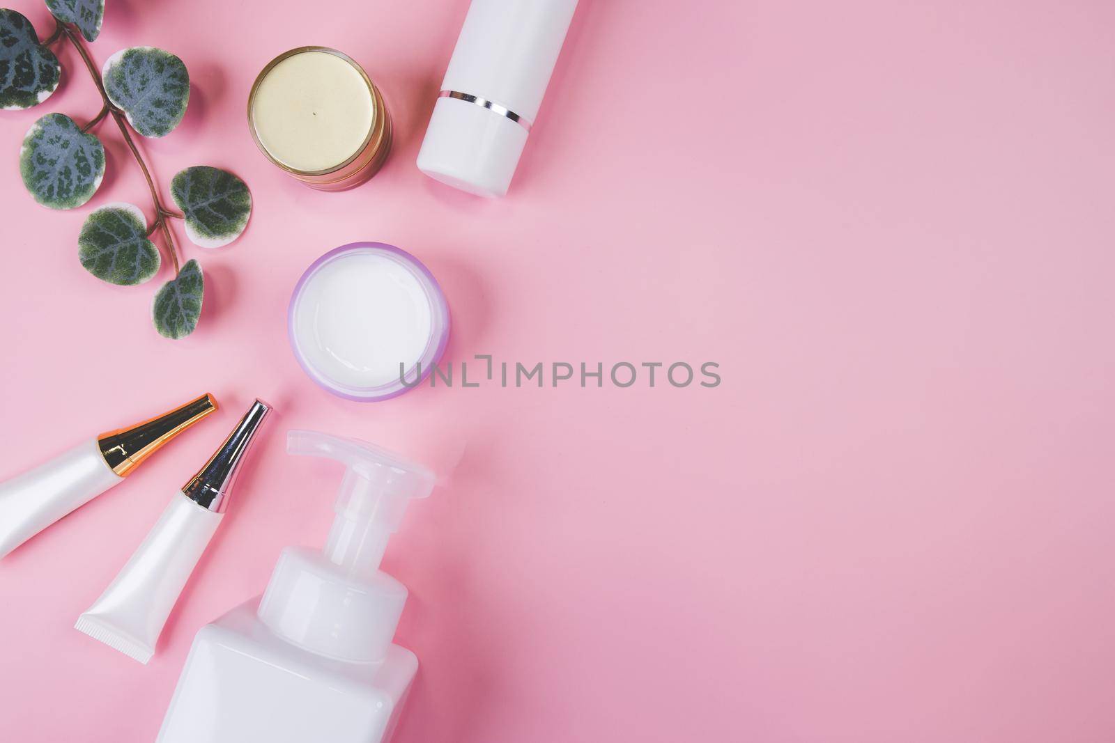 Mockup cosmetic bottle with cream or lotion and leaf isolated on pink background, mock up package for advertising, skincare or cosmetology, top view, flat lay, skin care and treatment with product. by nnudoo