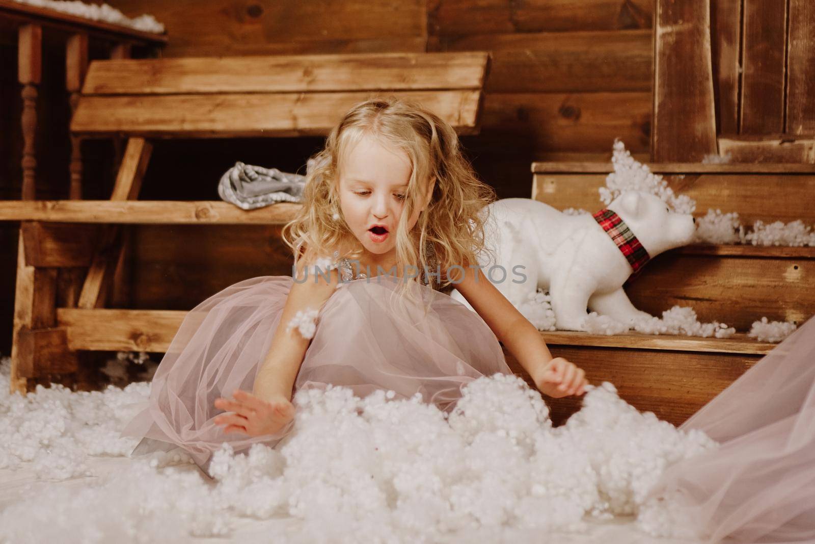 Little girl in pink dress is holding fake snow - christmas time