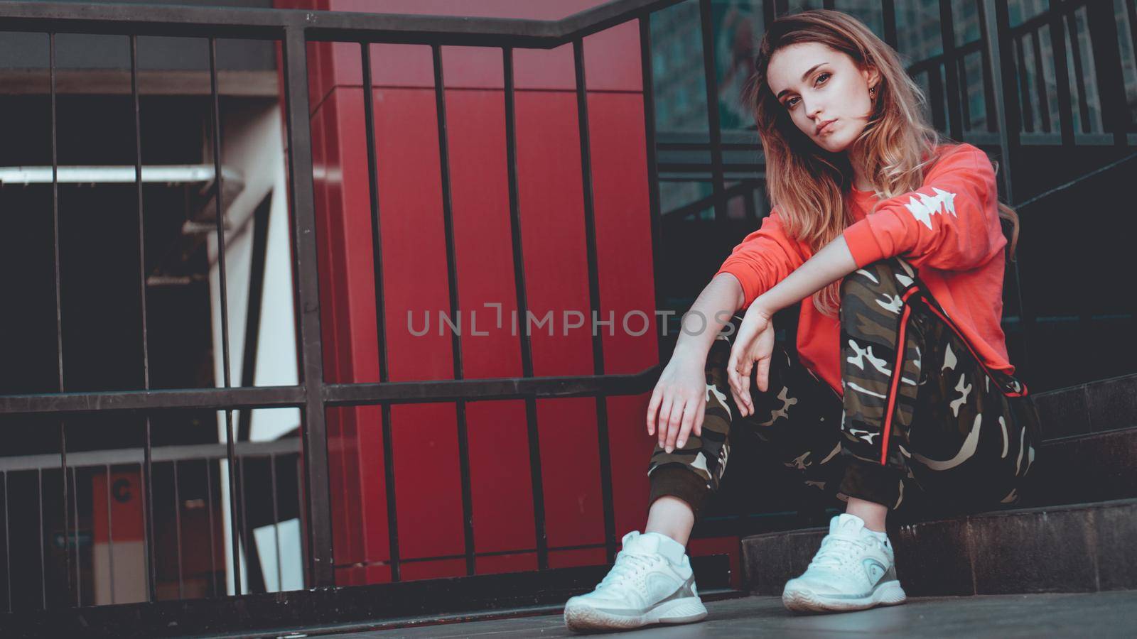 Fashion model wearing red hoodie with inscription los angeles posing at parking by natali_brill