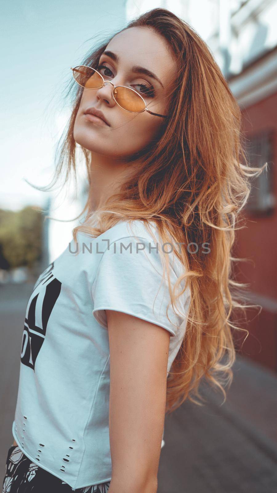 Fashion portrait stylish pretty woman in sunglasses posing in the city, street fashion