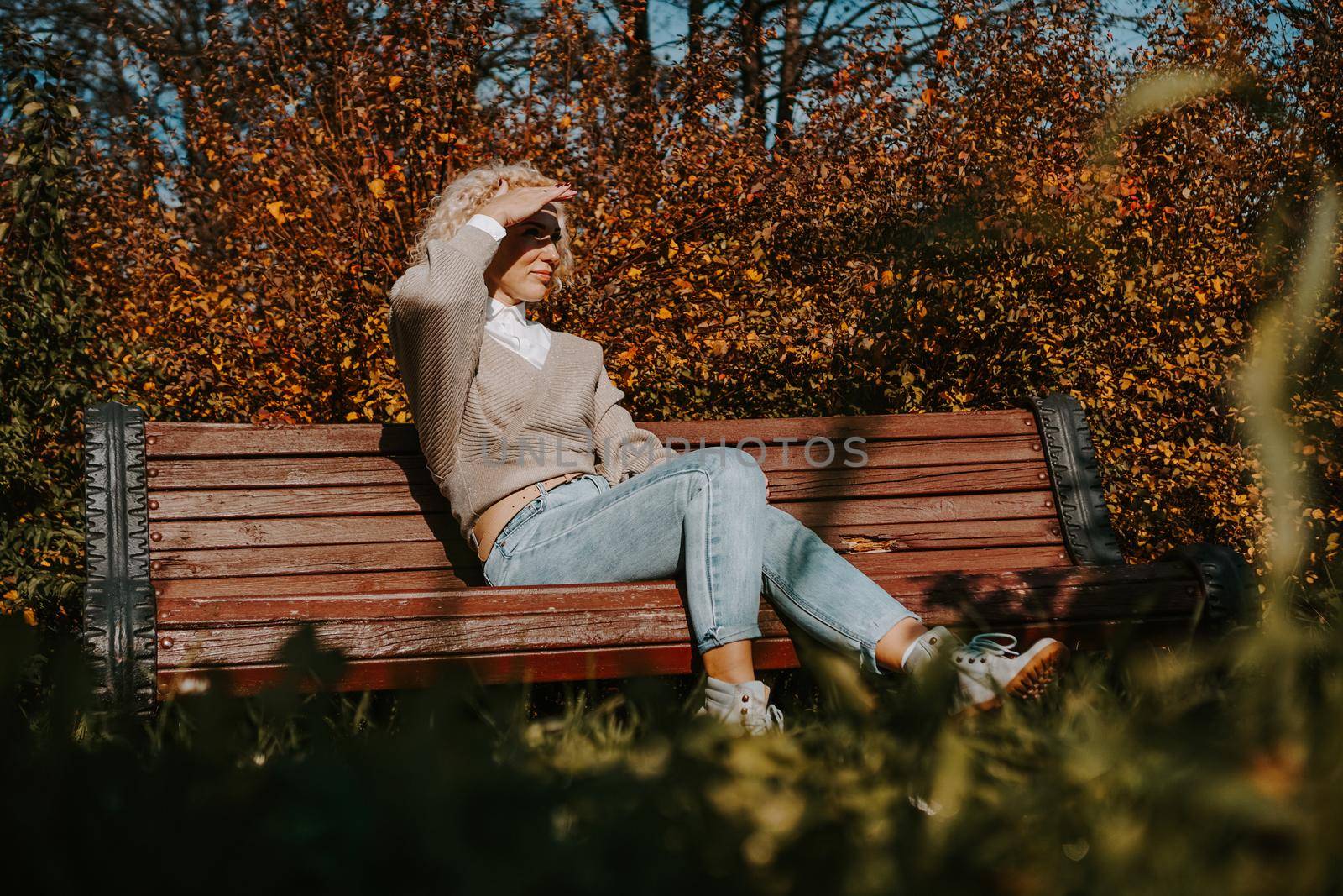 Middle-aged Woman sitting on the bench at autumn city park