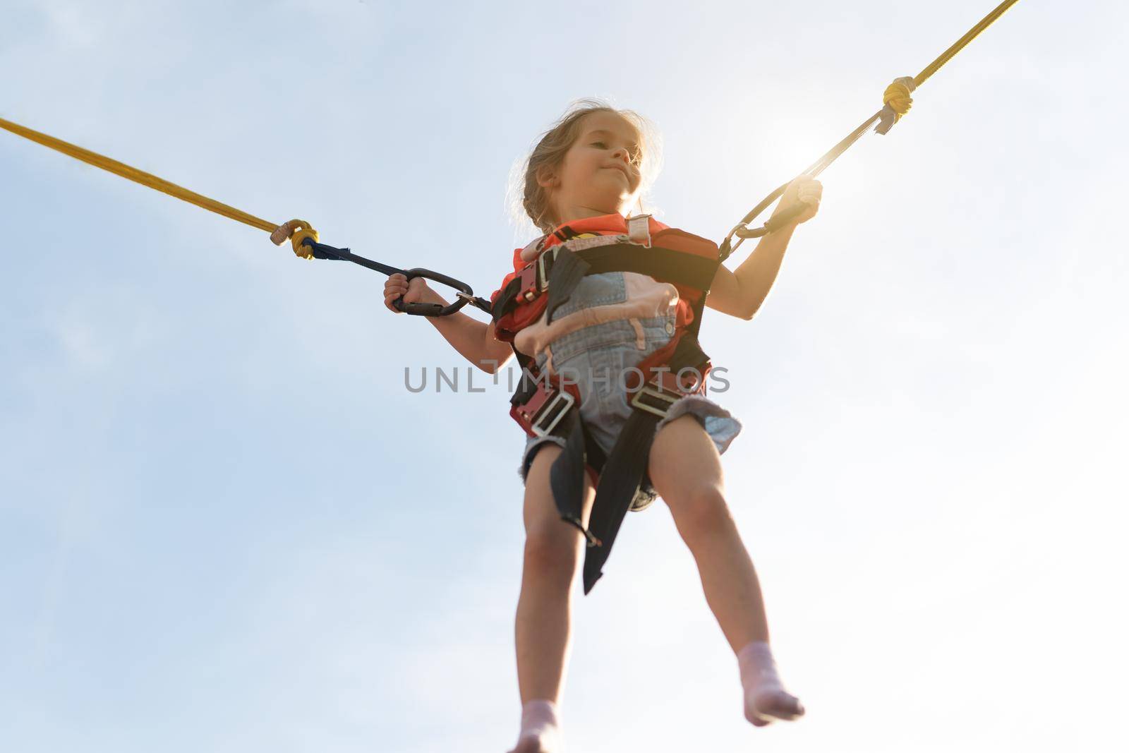 Child jumping child trampoline rubber bands Amusement park Little girl jump on attraction