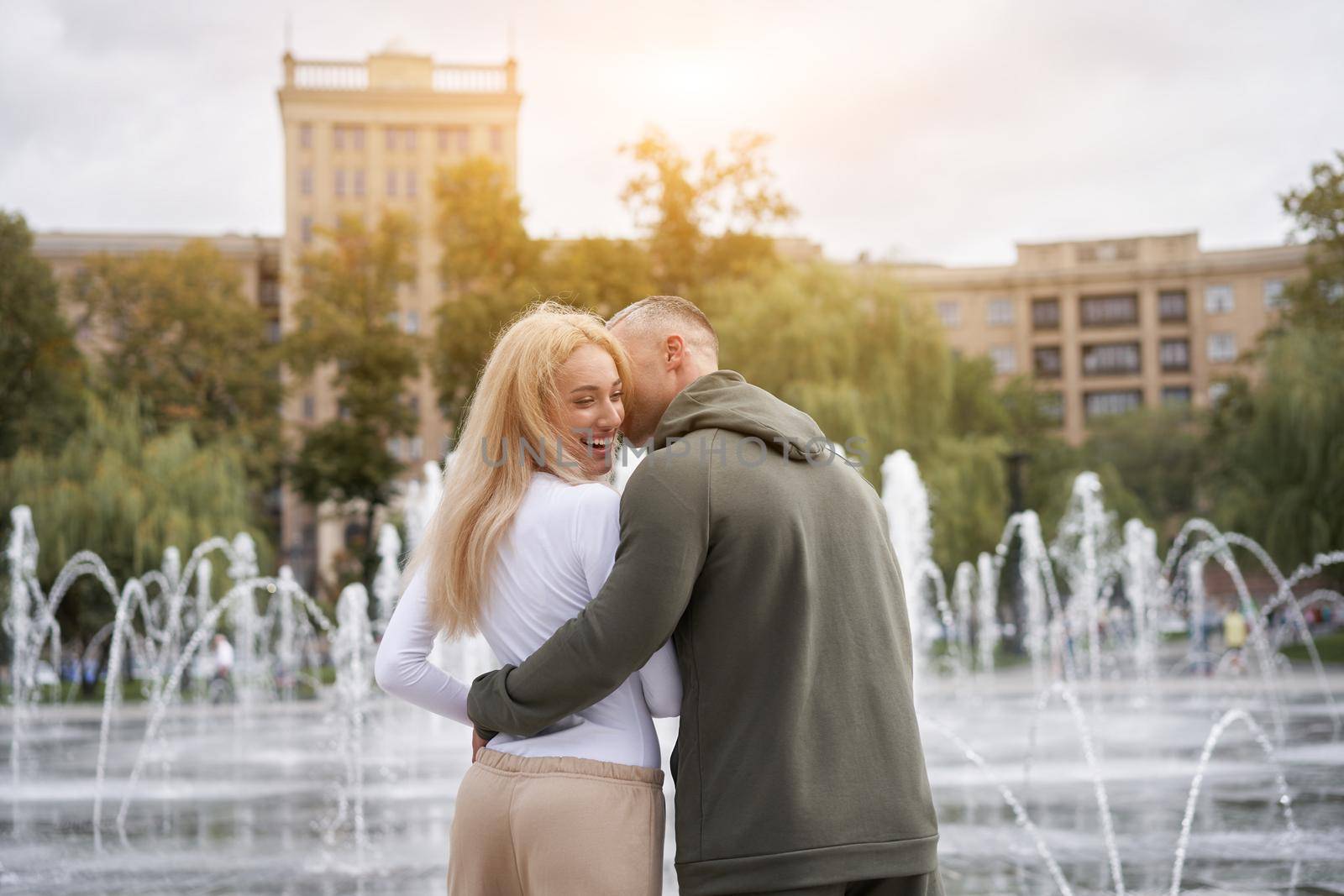 Couple in love walking outdoors park fountain Caucasian man woman walk outside after jogging dressed sport clothes by andreonegin
