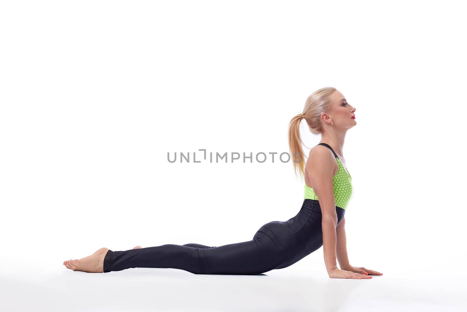 Peaceful sport. Horizontal profile shot of an attractive sportswoman stretching her back at studio against white background copyspace
