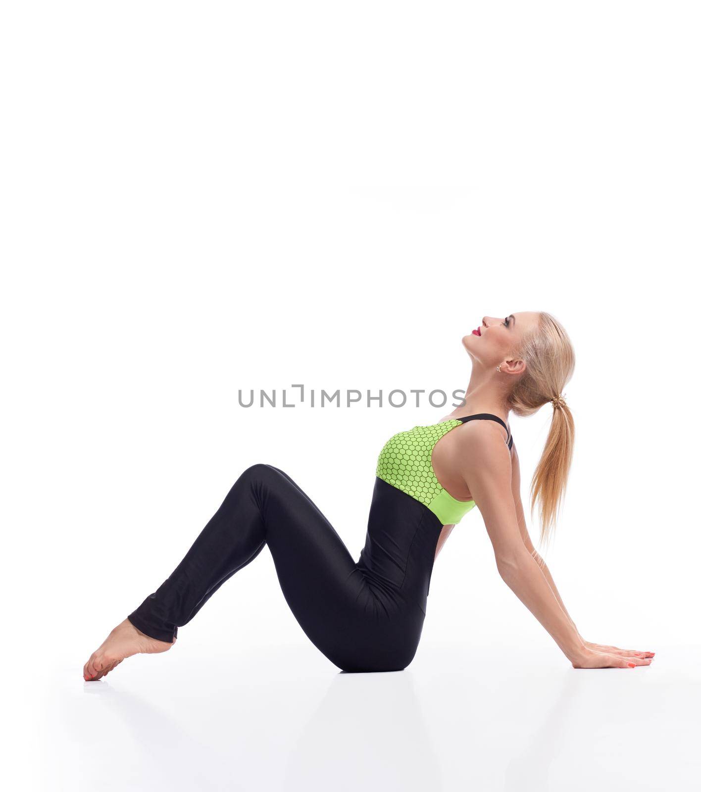 Gorgeous young woman practicing yoga sitting on the floor by SerhiiBobyk