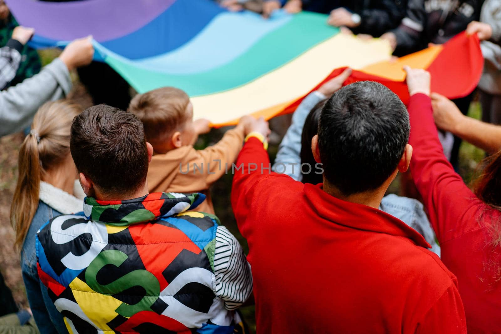 Unrecognizable people holding lgbt rainbow flag by andreonegin