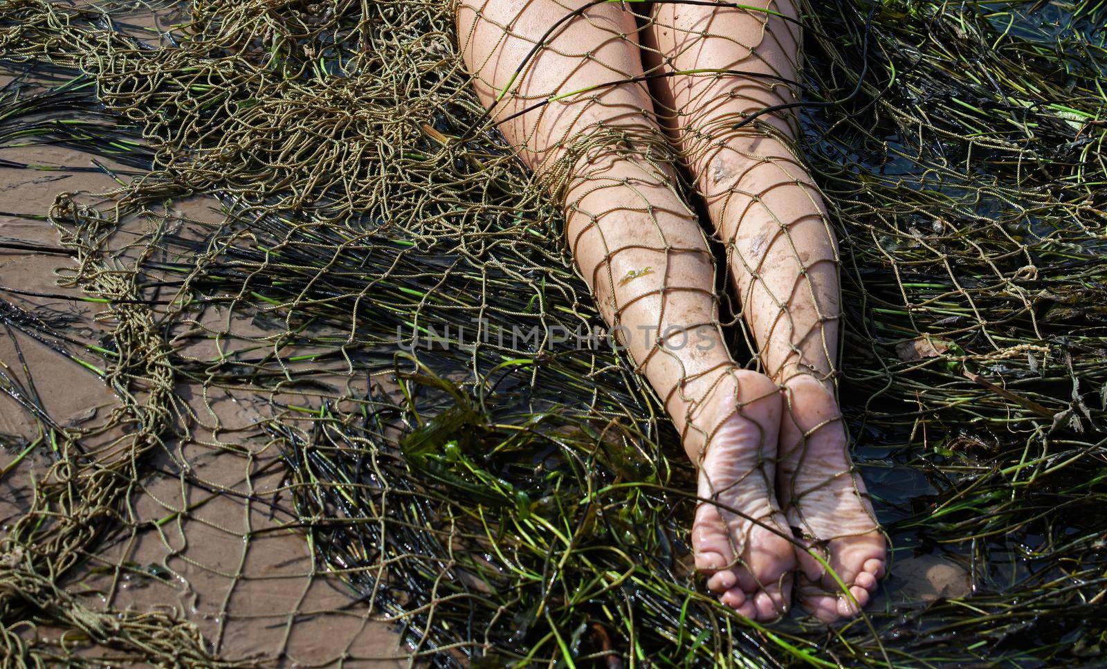 Young nude woman on the beach with a fishing net