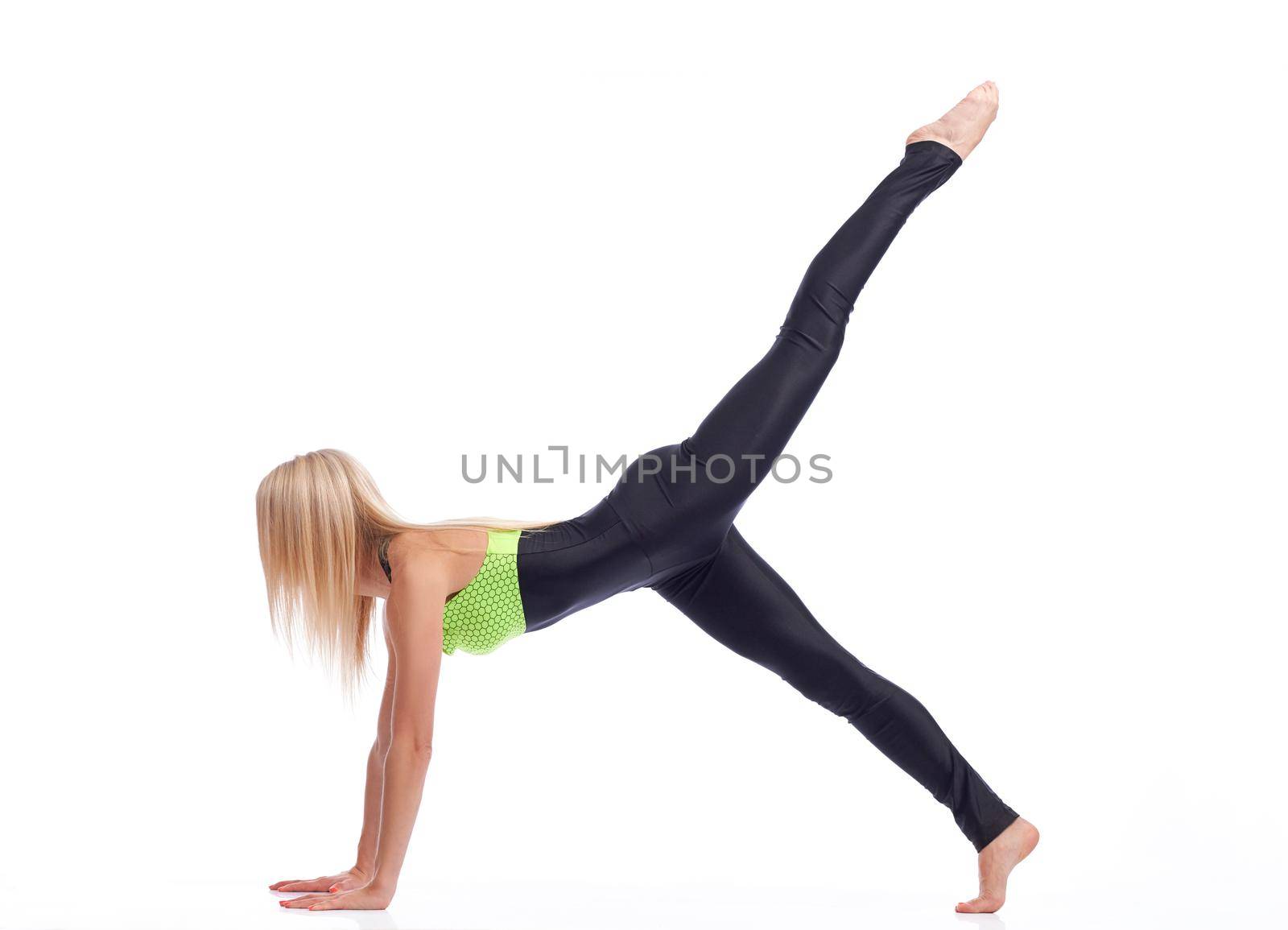 Sexy sports. Shot of a fitness woman with strong sexy body stretching at studio holding her leg up in the air doing plank exercise isolated copyspace body figure sexy sports fitness concept
