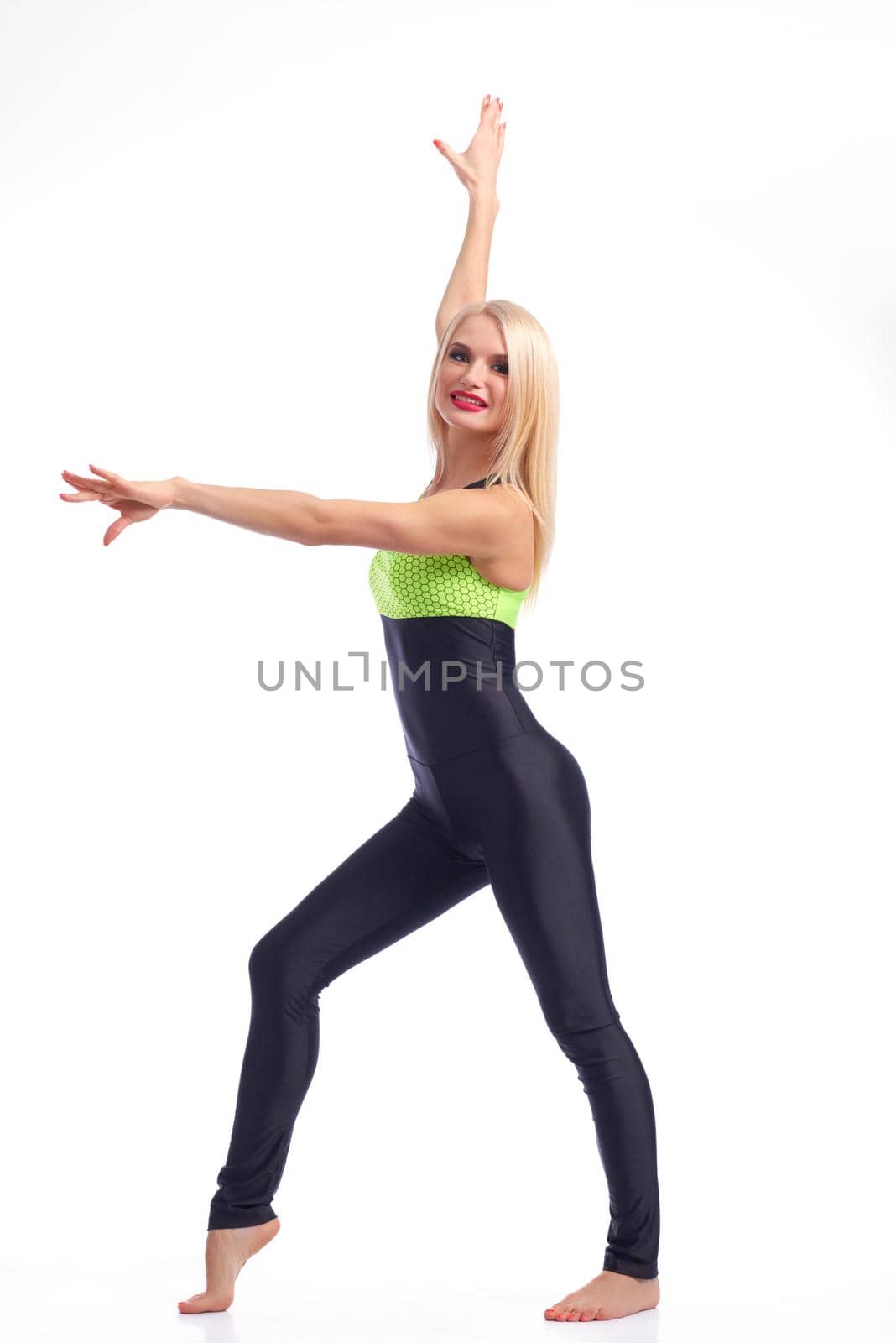 Grace of sporty. Full length shot of a beautiful blonde gymnast smiling cheerfully posing in her slim-fit tracksuit on white background