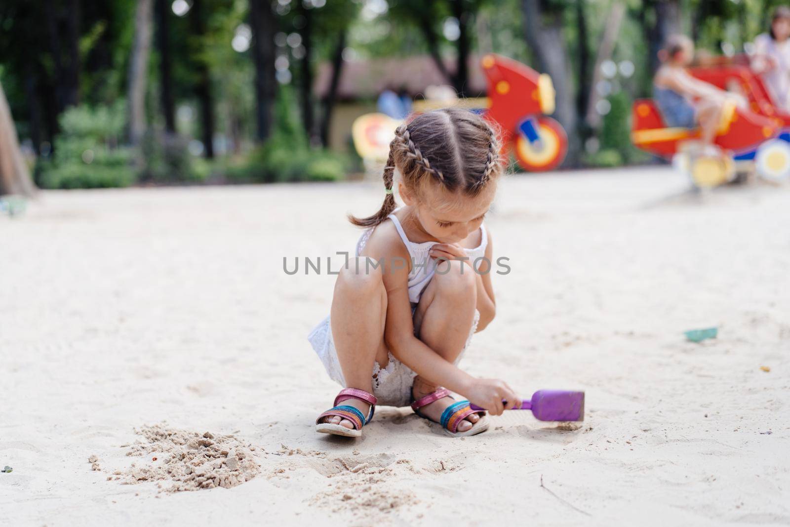 Little Girl Playing Sandbox Playground Digging Sand Shovel Building Sand Figure Summer Day. Caucasian Female Child 5 years Have Fun Outdoor