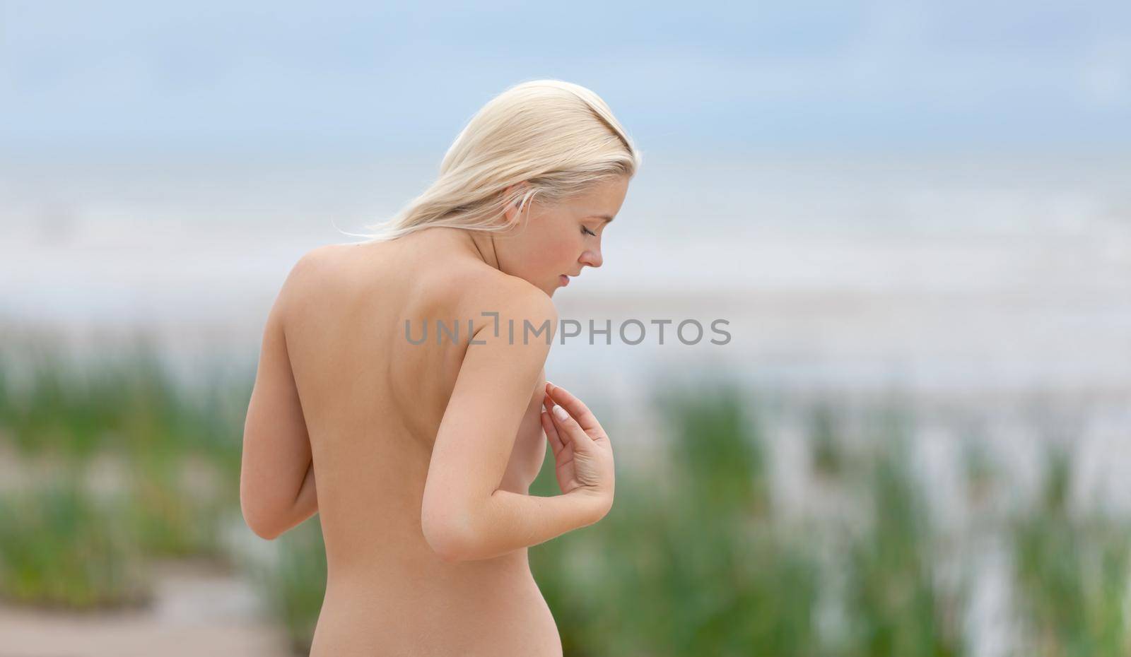 Portrait of a young naked woman on nature background. Natural beauty. Outdoor lifestyle portrait of beautiful young blonde woman on the beach. 