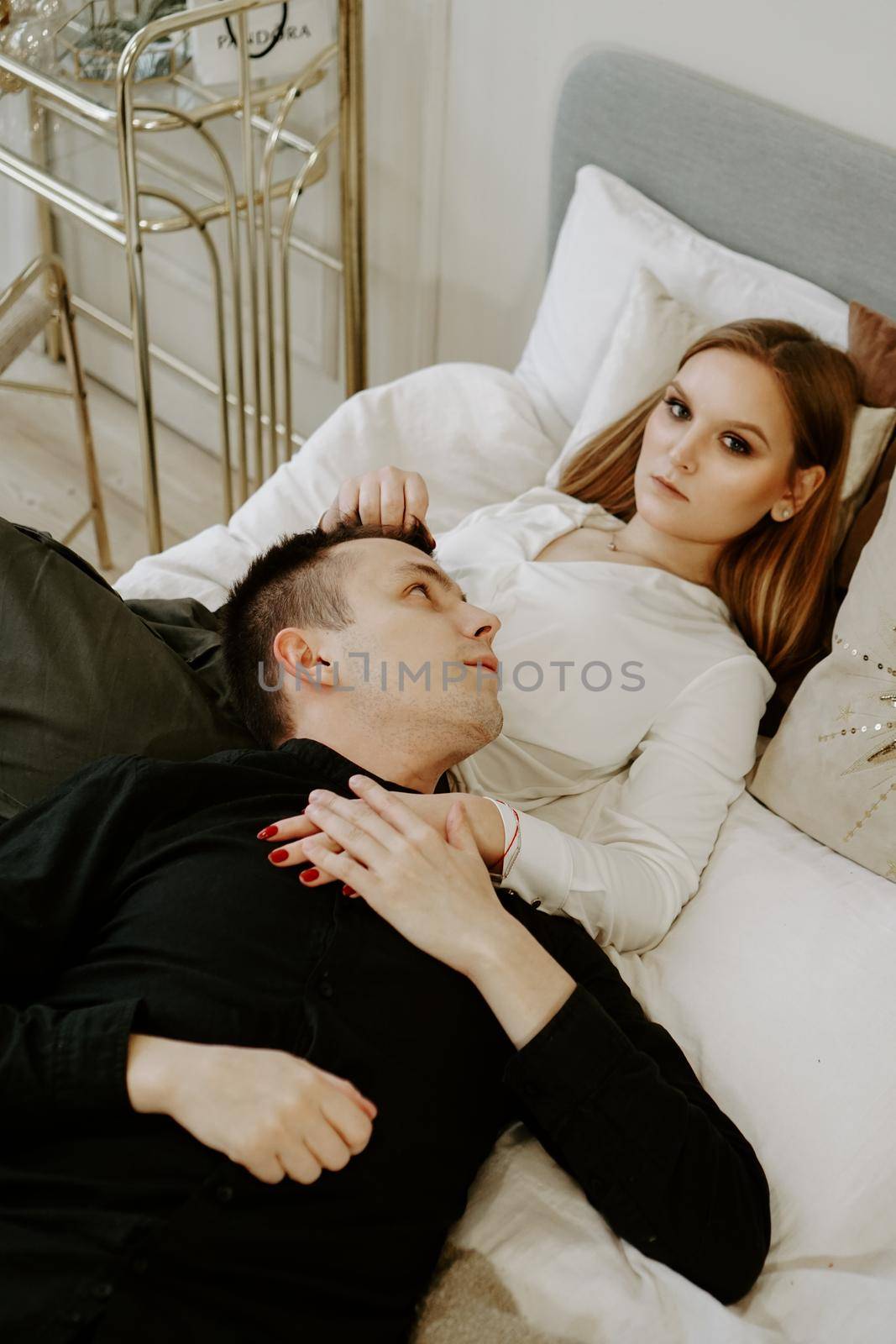 Business couple on bed in hotel room by natali_brill